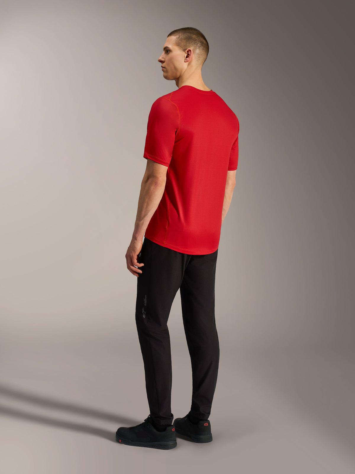 Camisola Alpinestars A-Dura Ride vermelha de mangas curtas, vista traseira com cauda mais longa e tecido elástico para BTT.