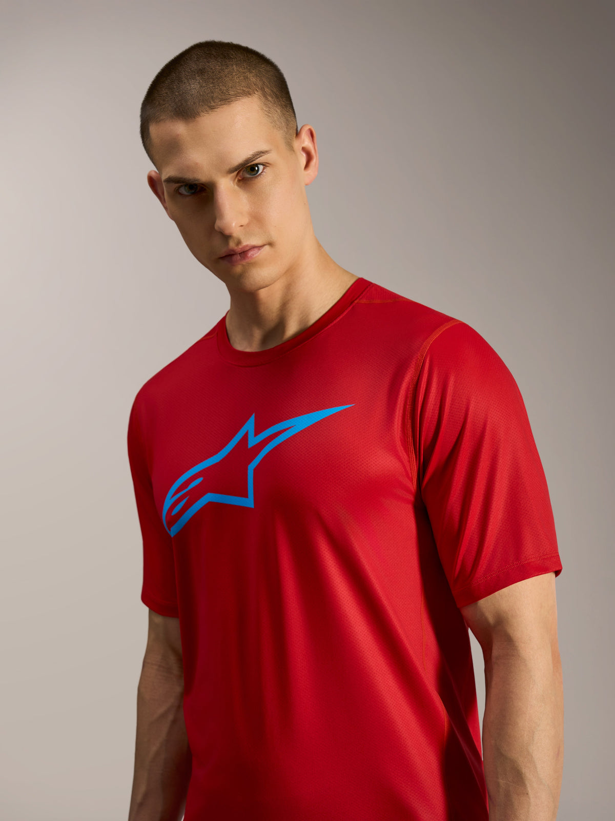 Camisola A-Dura Ride vermelha de mangas curtas, logótipo Astars azul, equipamento de performance leve para BTT e trilhos.