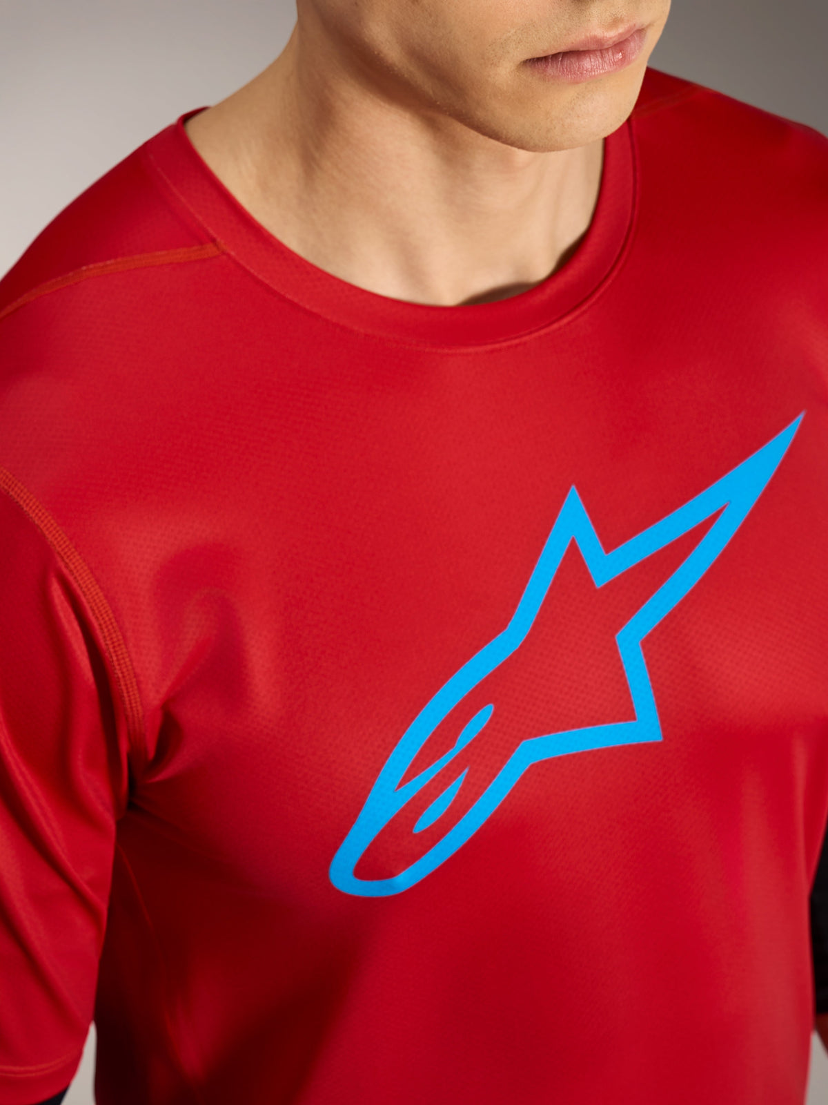 Camisola vermelha A-Dura Ride com logótipo Alpinestars azul, vestuário técnico de alta performance para BTT.