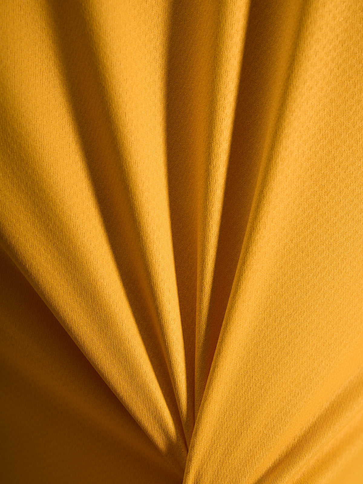Pormenor da textura cor de laranja da camisola A-Dura Ride em material leve de jacquard poliéster e spandex.