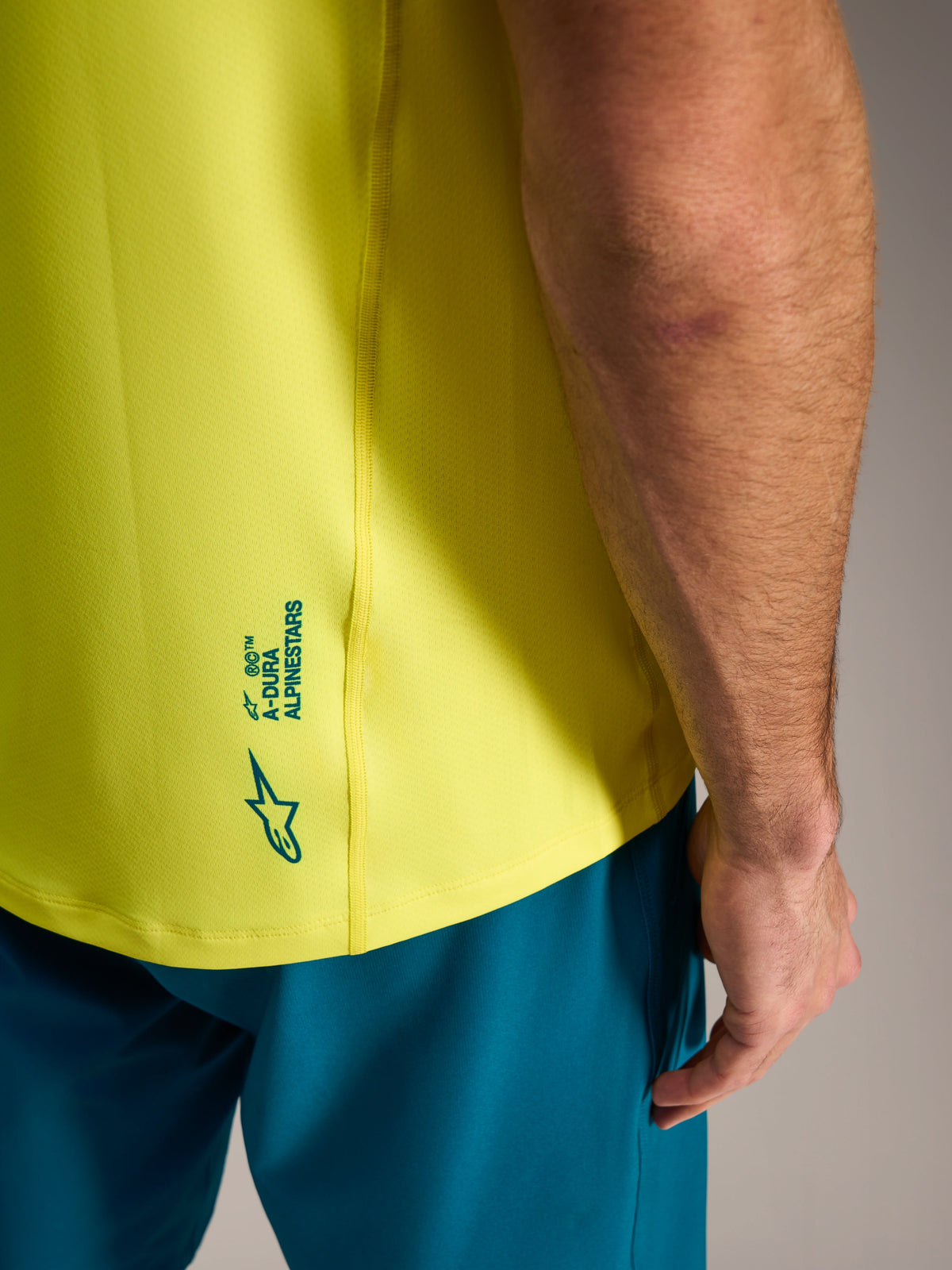 Camisola A-Dura Ride amarela fluo com detalhe Alpinestars na parte inferior das costas, vestuário leve de MTB.