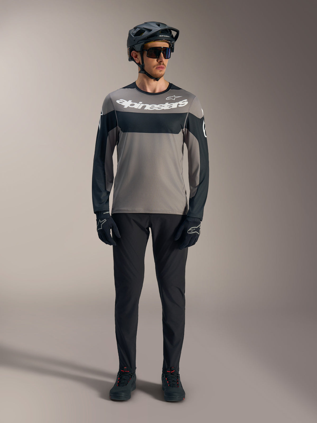 Camisola A-Dura Race de mangas compridas cinzenta e preta, logótipo Alpinestars branco e equipamento de performance MTB.