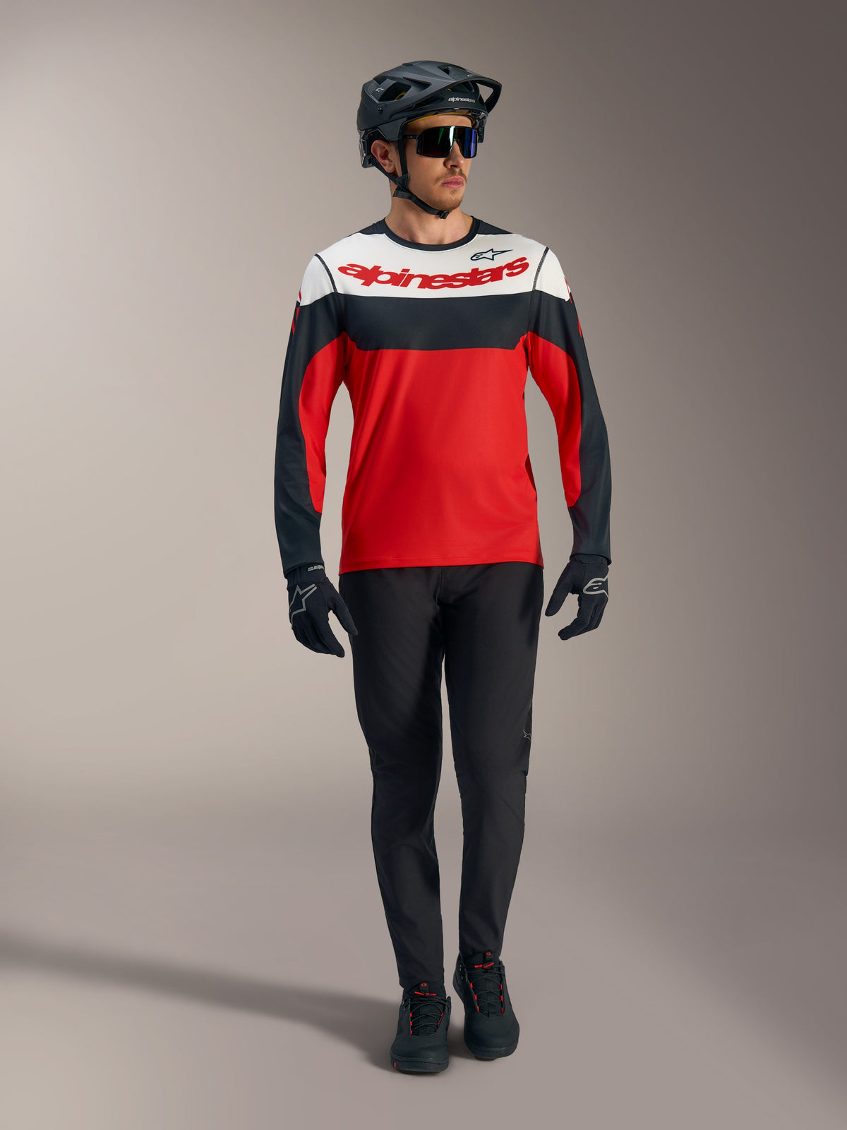 Red A-Dura Race Long Sleeve Jersey featuring white and black panels, paired with MTB pants and protective racing gear.
