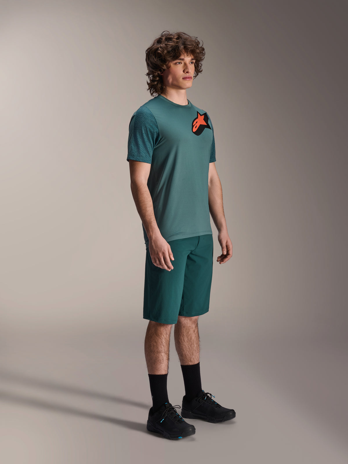 Alpinestars A-Dura Lipan SS Jersey and A-Dura Shorts, MTB Cycling Outfit, Dark Pine, jersey featuring a large orange star logo, paired with matching shorts and black footwear, performance mountain bike apparel