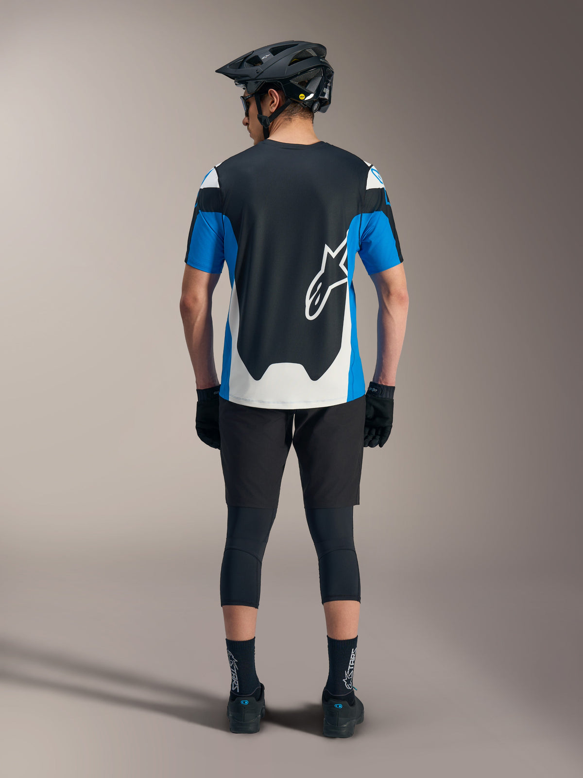 Camisola Alpinestars A-Dura Race SS azul e preta, com calções técnicos de MTB e equipamento de performance.