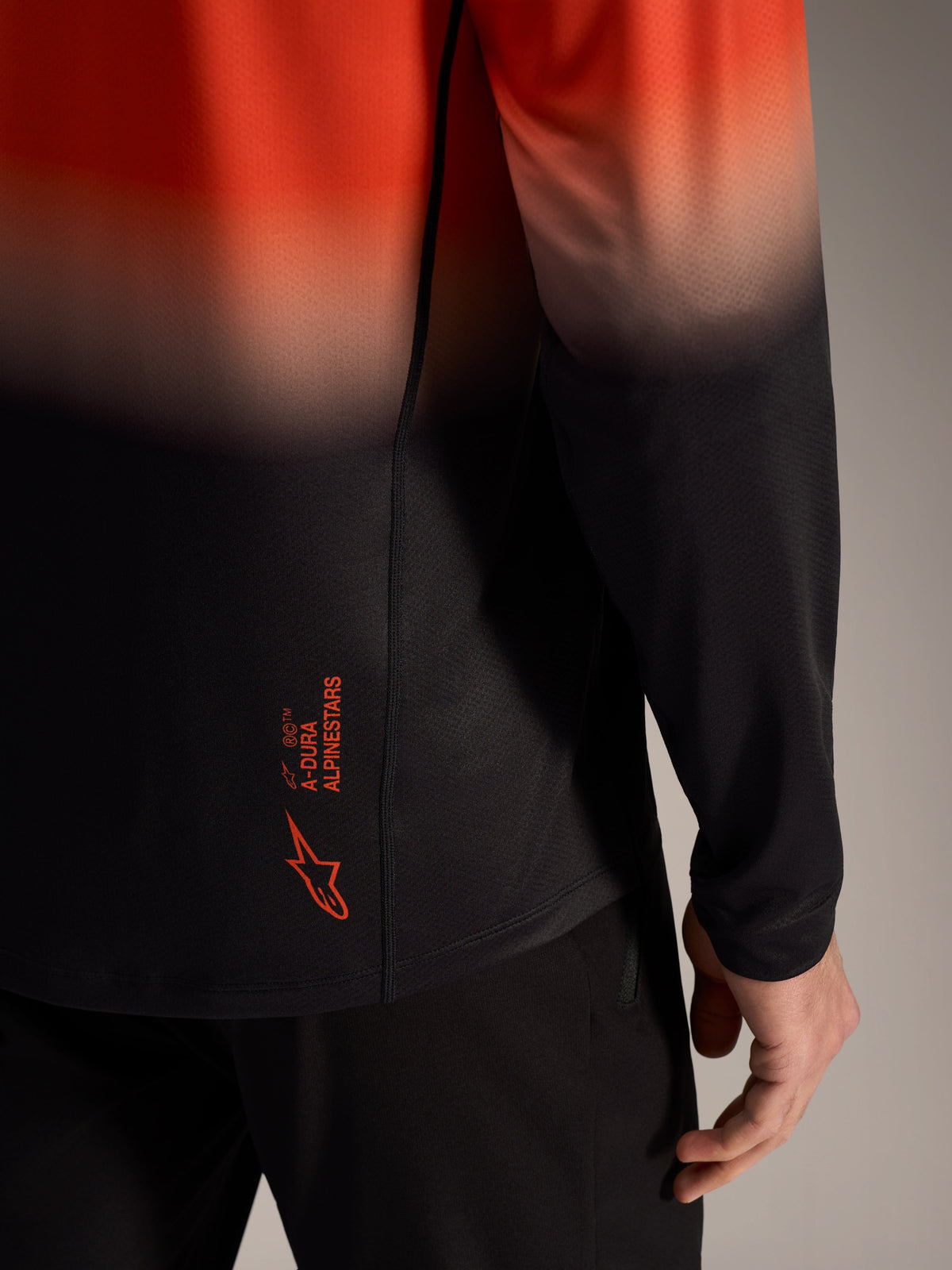 Camisola A-Dura ASTARS 2.0 em degradê laranja e preto, com logótipo nas costas e tecido jacquard respirável.