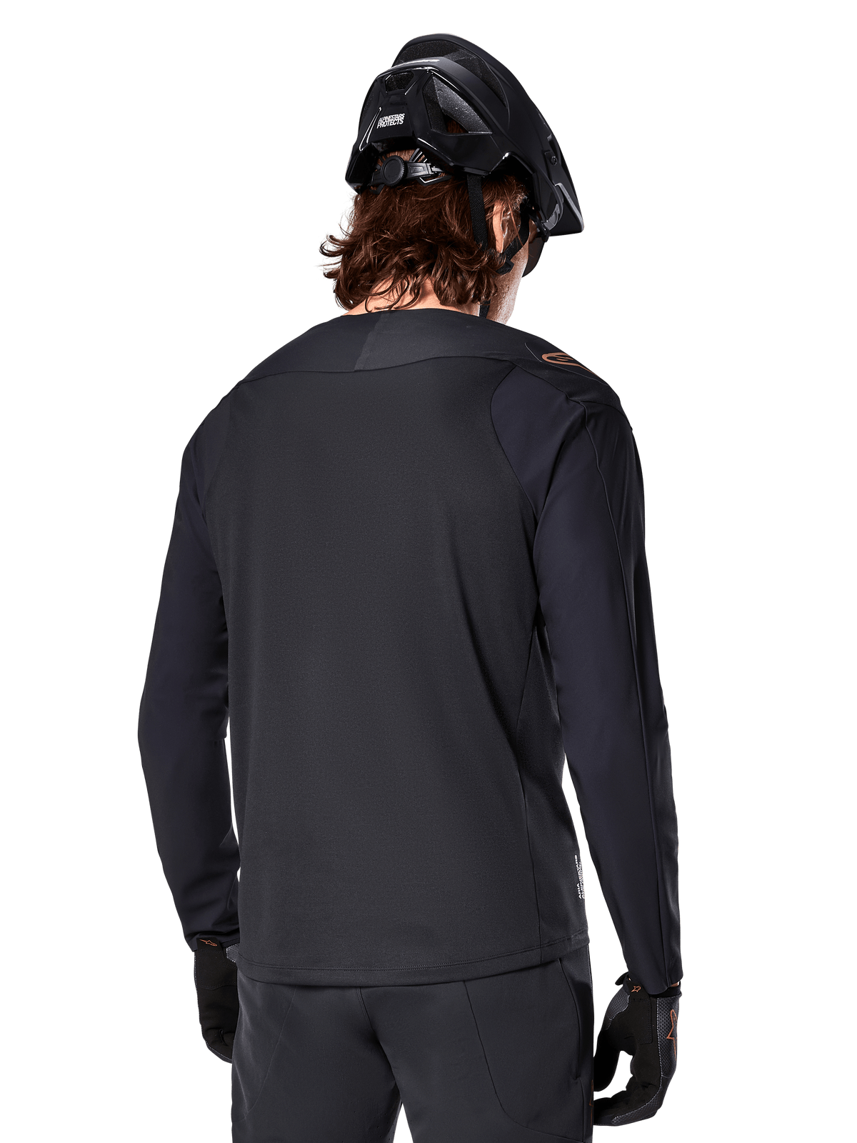 Alpinestars A-Aria Polartec Switch Jersey - Manga Longa, preta, vista de costas, usada com um capacete de BTT e luvas pretas, apresentando um design de cauda longa para desempenho fora de estrada