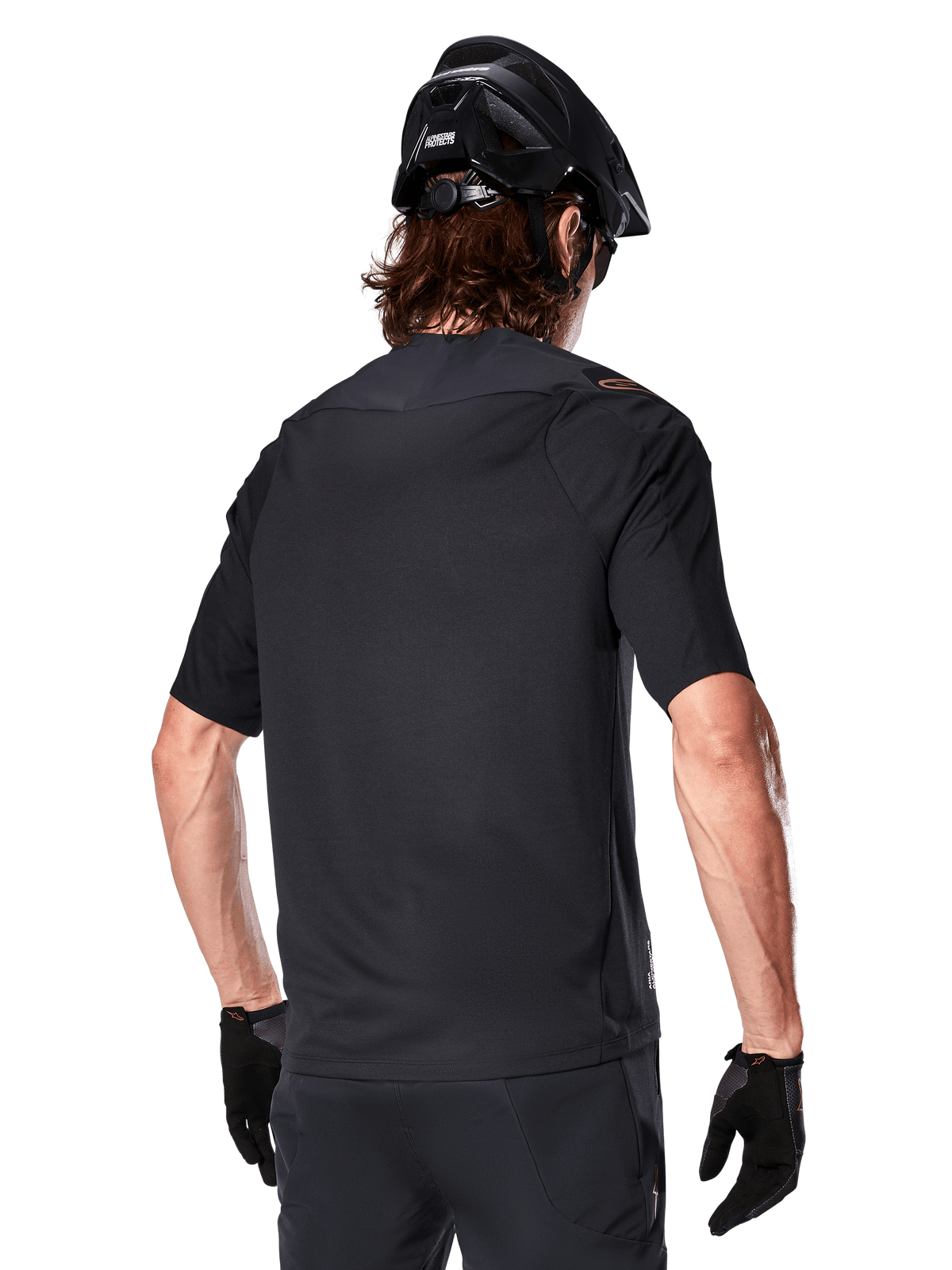 Alpinestars A-Aria Polartec Switch Short Sleeve Jersey, preta, vista traseira de um ciclista a usar um capacete de mountain bike preto, calções e luvas pretos a condizer, equipamento de performance para mountain bike