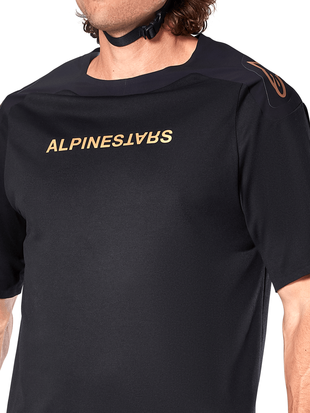 Alpinestars A-Aria Polartec Switch Jersey, camisola de BTT de manga curta, preta, letras Alpinestars douradas no peito e logótipo no ombro, detalhe do tronco superior destacando o tecido técnico e o ajuste de performance