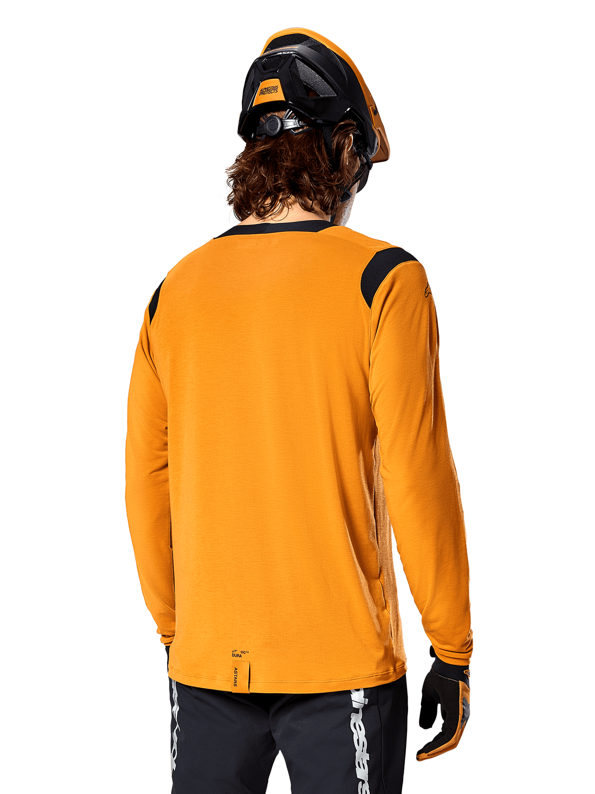 Camisola de Manga Comprida Alpinestars A-Dura Dri Wool em Dark Gold, vista traseira de um ciclista com capacete de BTT e luvas, apresentando painéis de malha pretos nos ombros e uma cauda mais longa, vestuário técnico de ciclismo para trilhos
