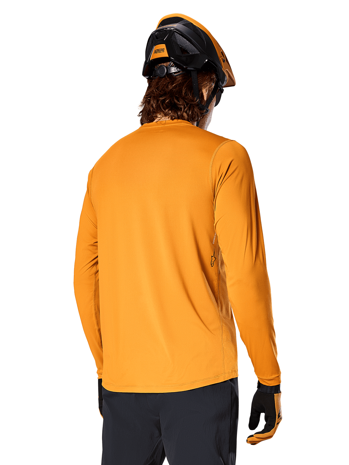 Alpinestars A-Dura Rocker Long Sleeve Jersey, Dark Gold, back view of rider wearing a black and orange MTB helmet, dark pants, and matching gloves, casual performance mountain bike apparel