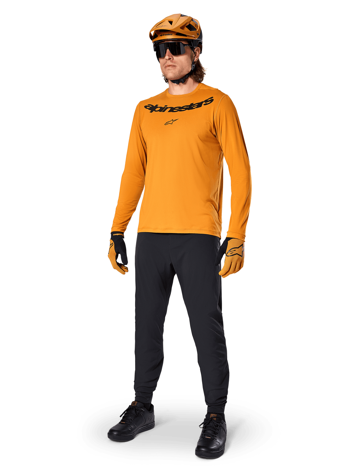 Alpinestars A-Dura Rocker Long Sleeve Jersey, Dark Gold cycling jersey, worn with matching MTB helmet and black pants, featuring black wordmark chest logo, coordinated performance gear for off-road mountain biking