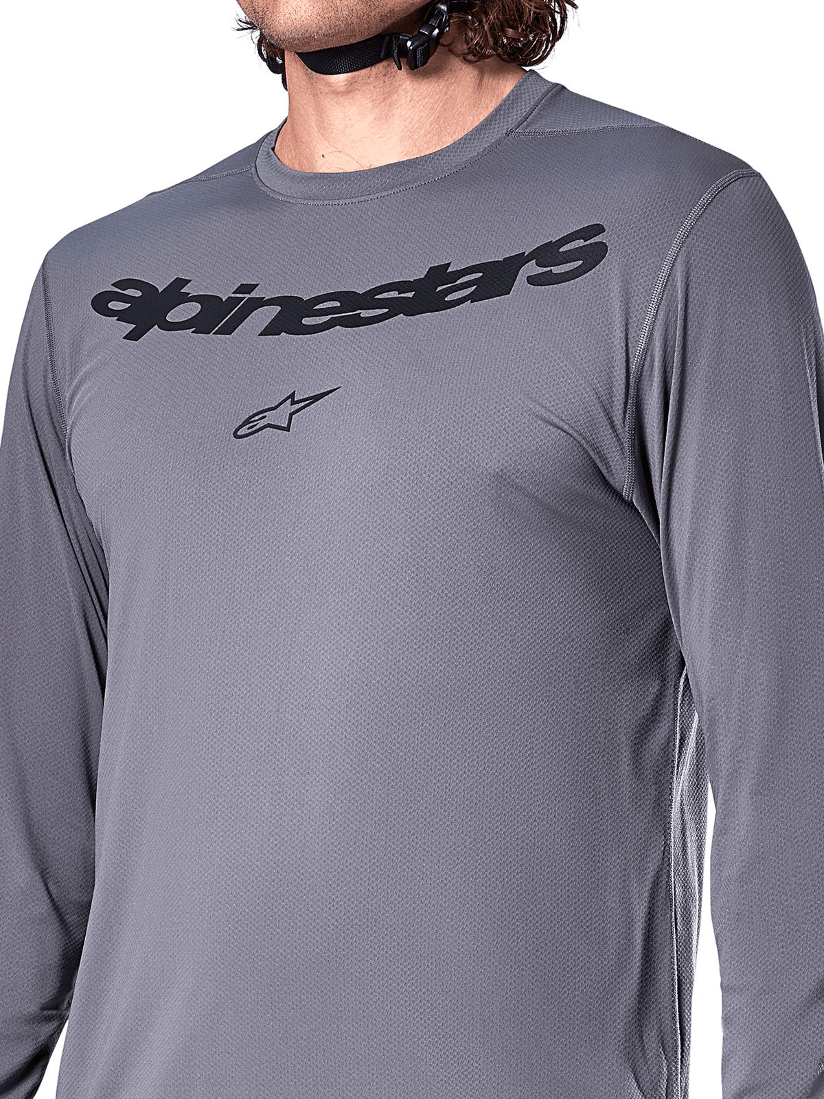 Camisola Alpinestars A-Dura Rocker de Manga Comprida, cinza escuro, grande plano do peito com o nome e o logótipo da estrela Alpinestars em preto, material jacquard de poliéster e elastano, vestuário de performance para bicicleta de montanha