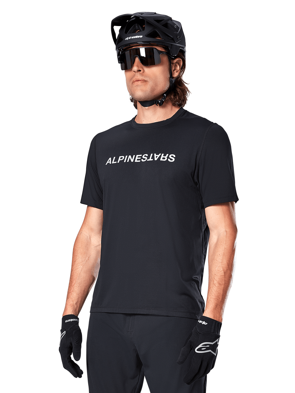 Camisola Alpinestars A-Dura Switch de manga curta para homem, preta com logótipo branco, em tecido técnico para MTB trail, vestida por um ciclista.