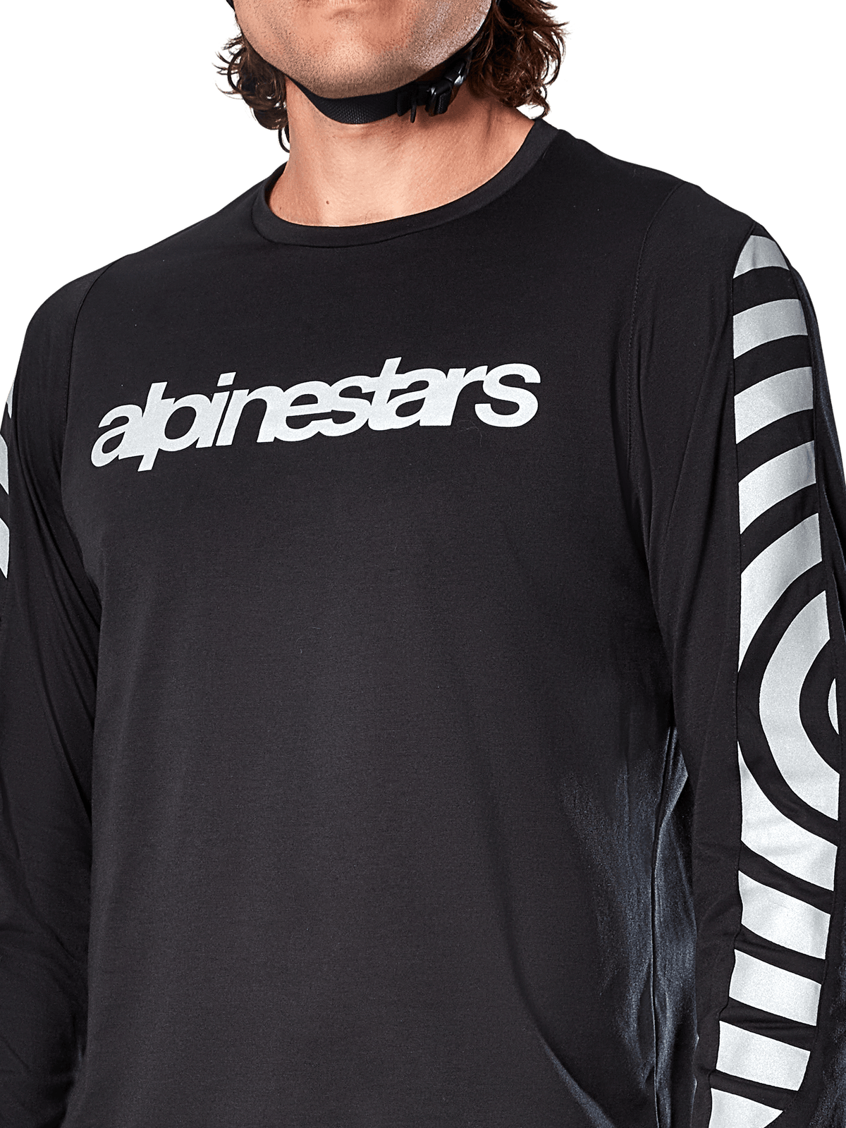 Camisola de Manga Comprida Alpinestars A-Dura Dri Oscar, Preto Refletor, vista em pormenor mostrando o logótipo Alpinestars branco no peito e gráficos circulares refletores nas mangas, vestuário técnico de ciclismo para BTT
