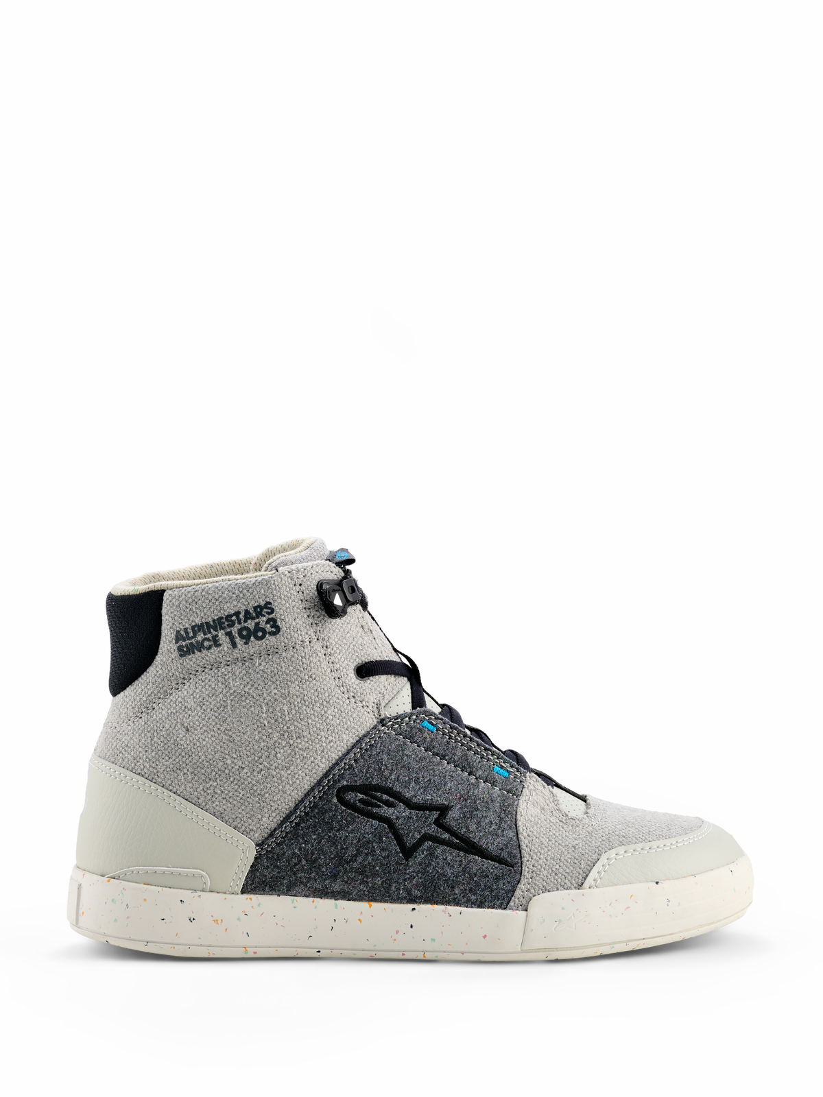 Alpinestars Circal Riding Shoes, sapatilhas de motociclismo de cano alto em Cinzento, Preto e Azul Methyl, painéis de lona cinzenta clara e tecido texturizado cinzento-escuro, sola de borracha branca com salpicos coloridos reciclados, logótipo de estrela Alpinestars em preto, marcação no tornozelo "ALPINESTARS SINCE 1963", estilo de condução urbano moderno