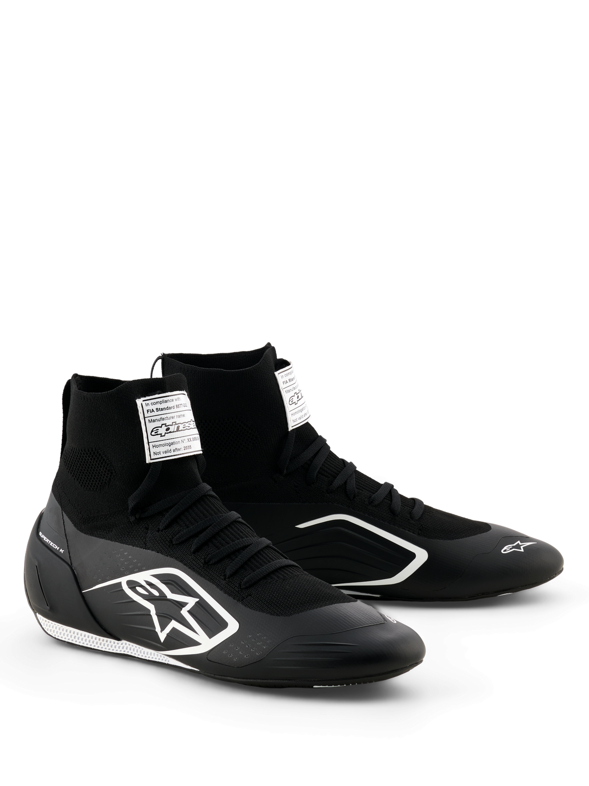 Sapatos Alpinestars Supertech K - FIA, sapatos de karting, pretos e brancos, parte superior totalmente em malha com ajuste tipo meia de cano alto, logótipo Alpinestars branco na lateral, etiqueta branca de certificação FIA na língua, design leve e elegante para performance em corrida