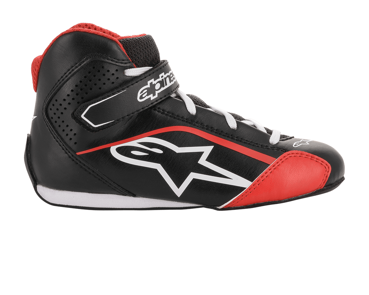 Sapatos Alpinestars Youth Tech-1 K, sapatos de karting, pretos, brancos e vermelhos, perfil lateral com construção em microfibra, logótipo Alpinestars branco, alça de gancho e laço no tornozelo e painéis laterais perfurados para ventilação.