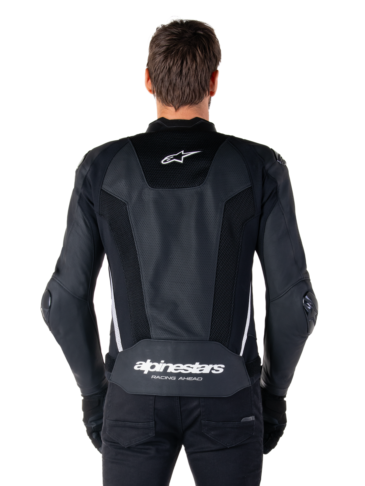 Alpinestars Missile V3 Airflow Leather Jacket, Black and White, back view worn by a rider, featuring extensive perforated leather panels, white side accents, Alpinestars star logo on the upper back, and 'alpinestars RACING AHEAD' branding on the lower back.