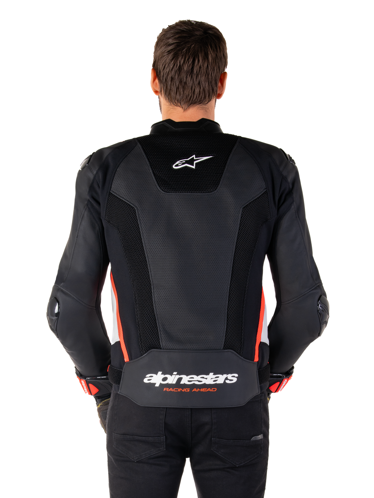Vista traseira de uma pessoa a usar o casaco de couro Alpinestars Missile V3 Airflow em Preto Branco Vermelho Fluo, com painéis extensos de couro perfurado para ventilação, um pequeno logótipo Alpinestars na parte superior das costas e a marca 'alpinestars RACING AHEAD' em destaque na zona inferior da cintura.