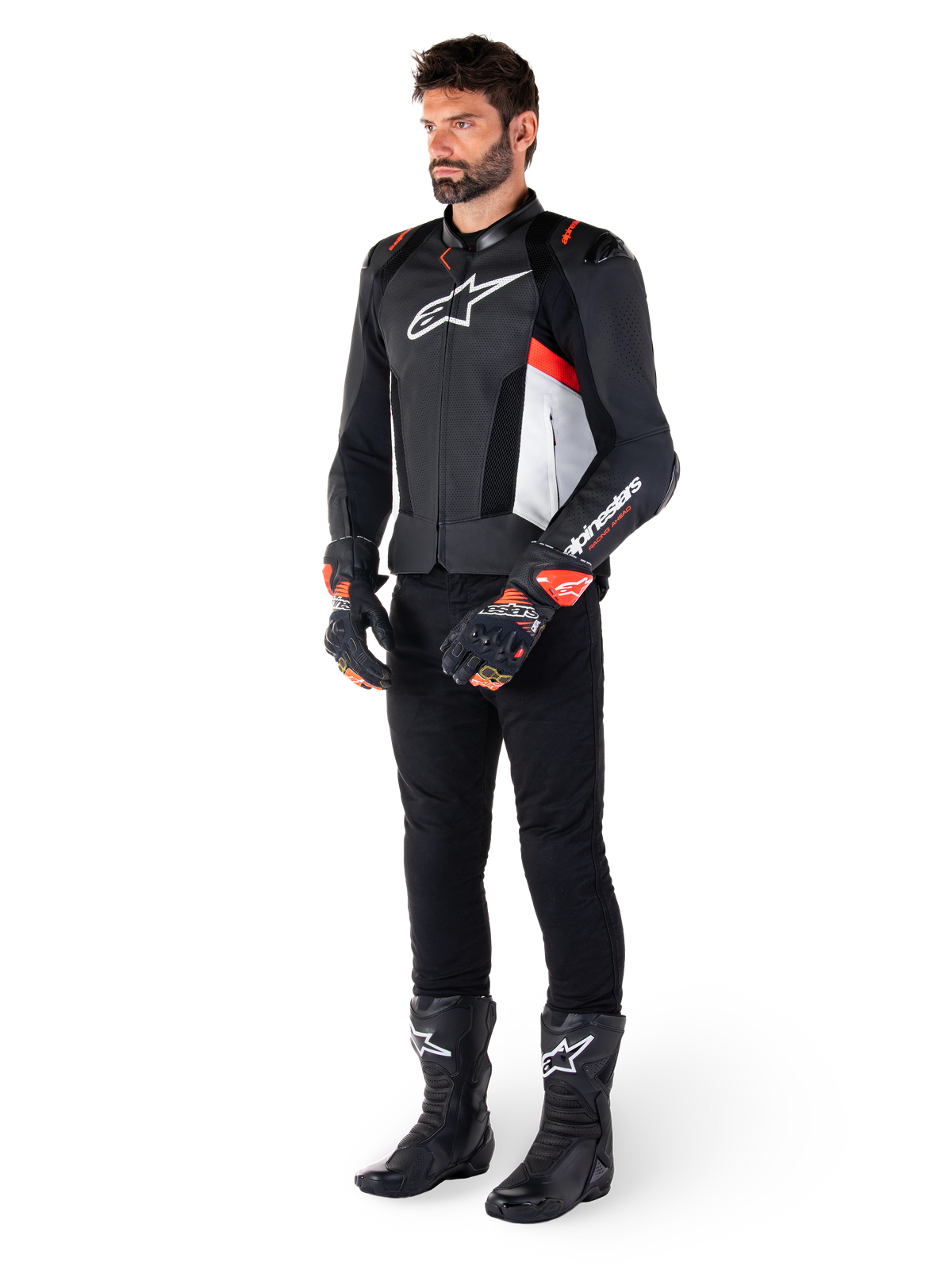 Casaco de Couro Alpinestars Missile V3 Airflow, preto, branco e vermelho fluo, vestido por um modelo masculino com calças pretas, luvas de corrida pretas e botas pretas, com couro perfurado para ventilação, logótipo branco no peito e detalhes em vermelho fluo, concebido para alta performance de corrida e desporto