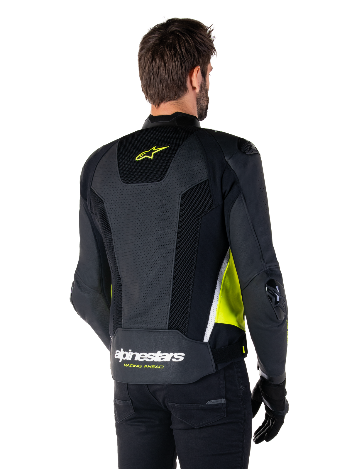 Alpinestars Missile V3 Airflow Leather Jacket, vista traseira num modelo masculino, preto com detalhes em amarelo fluorescente e branco, com painéis extensos de couro perfurado e malha nas costas, logótipo da estrela a amarelo e texto 'RACING AHEAD' a branco, combinado com luvas e calças pretas.