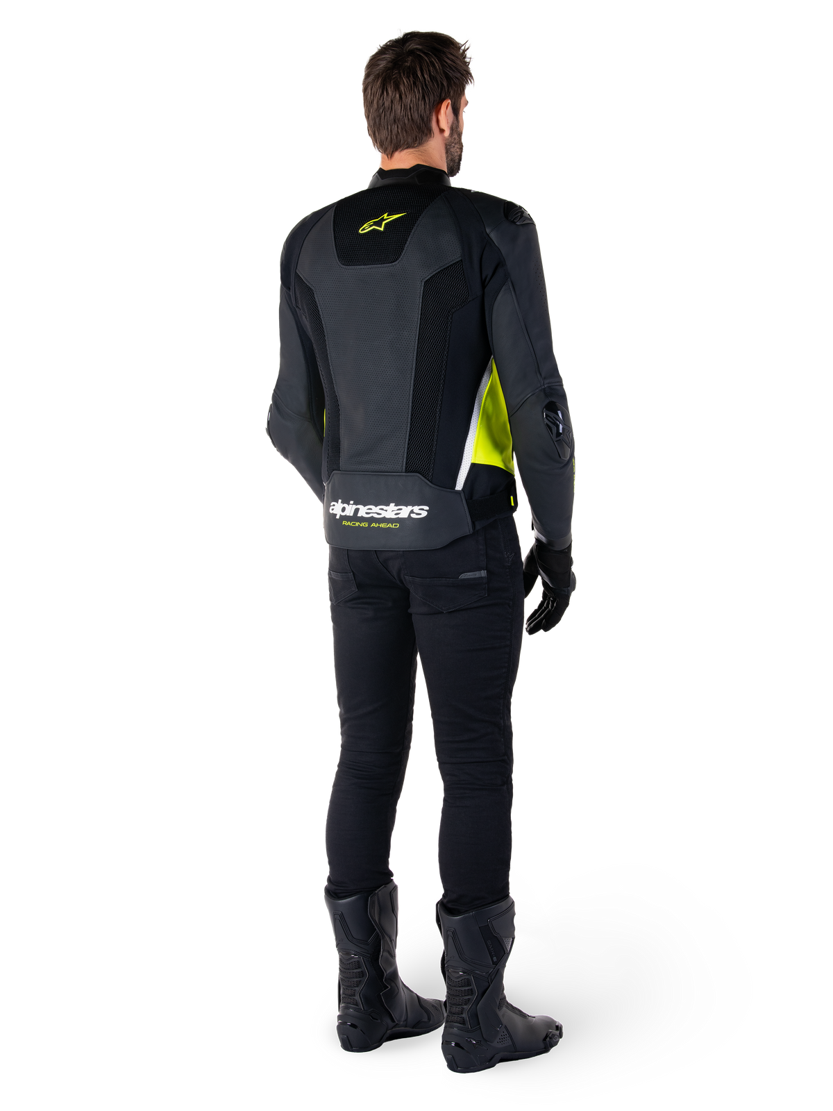 Casaco de Couro Alpinestars Missile V3 Airflow, preto, amarelo fluo e branco, vista traseira no piloto, com painéis traseiros em couro perfurado, logótipo amarelo da Alpinestars e detalhes em branco, usado com calças e botas de motociclista pretas