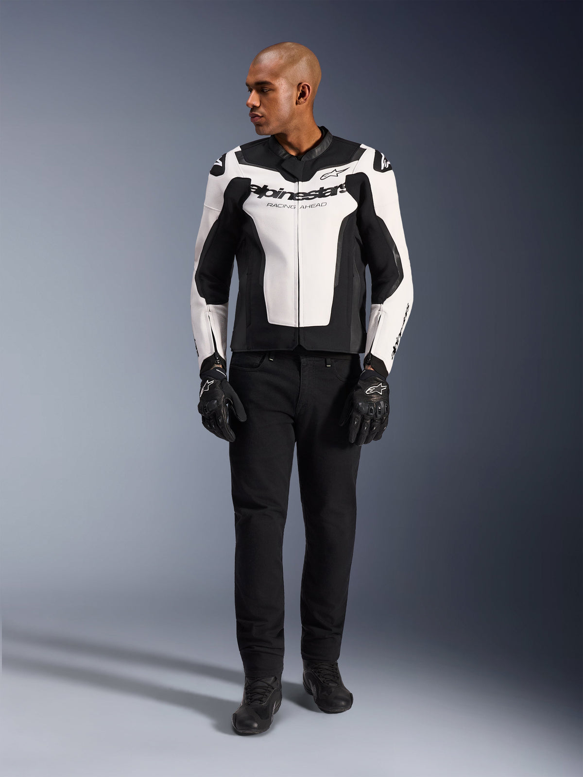 Alpinestars GP Force V2 Leather Jacket, White and Black, full-body view on a model wearing black pants and gloves, featuring multi-panel leather construction with Alpinestars branding on the chest and sleeves, sporty design for motorcycle riding