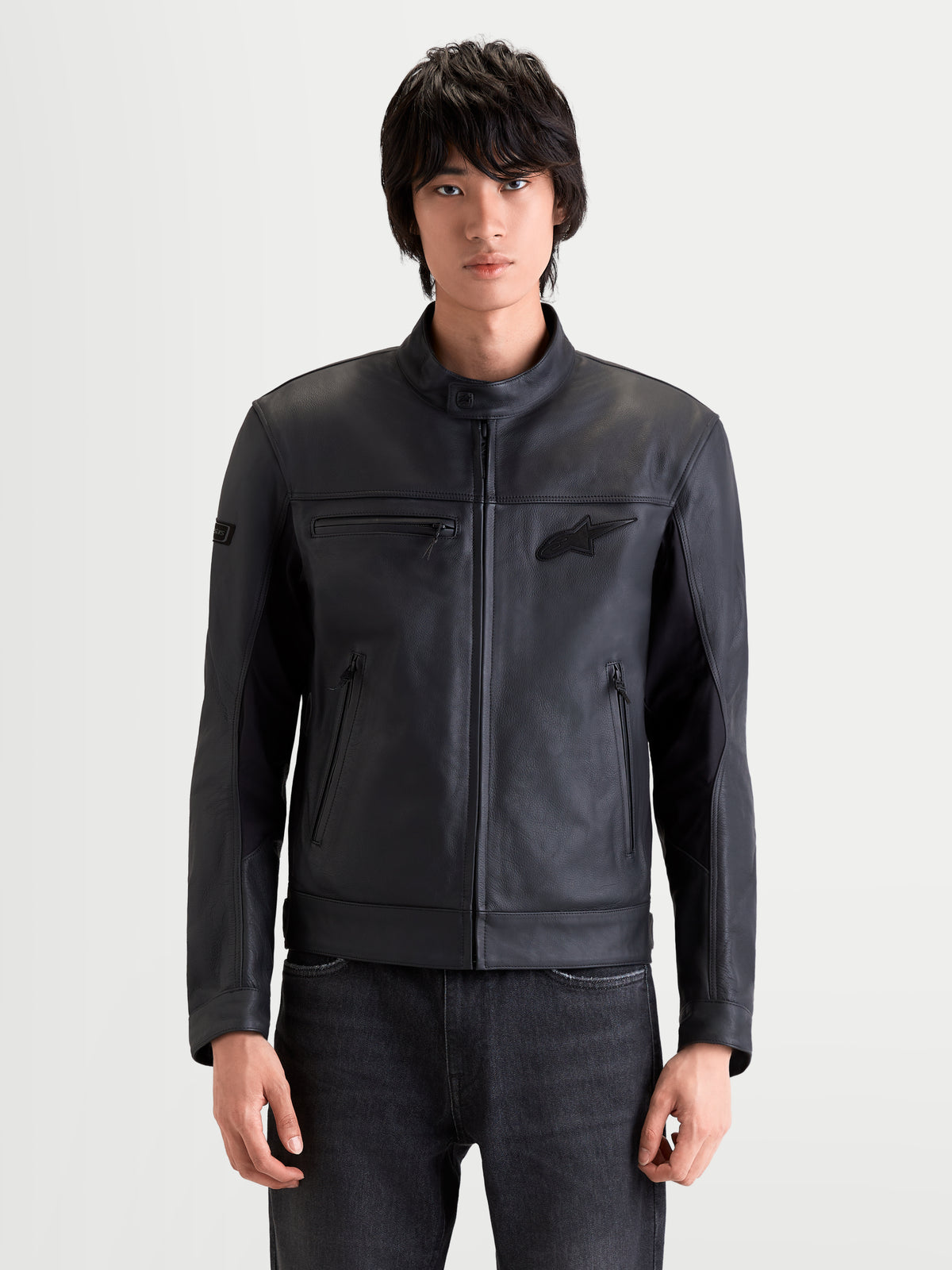 Alpinestars Maver X casaco de moto para homem, casaco de pele urbano contemporâneo preto, vista frontal num modelo a vestir equipamento de proteção em couro bovino premium com inserções elásticas