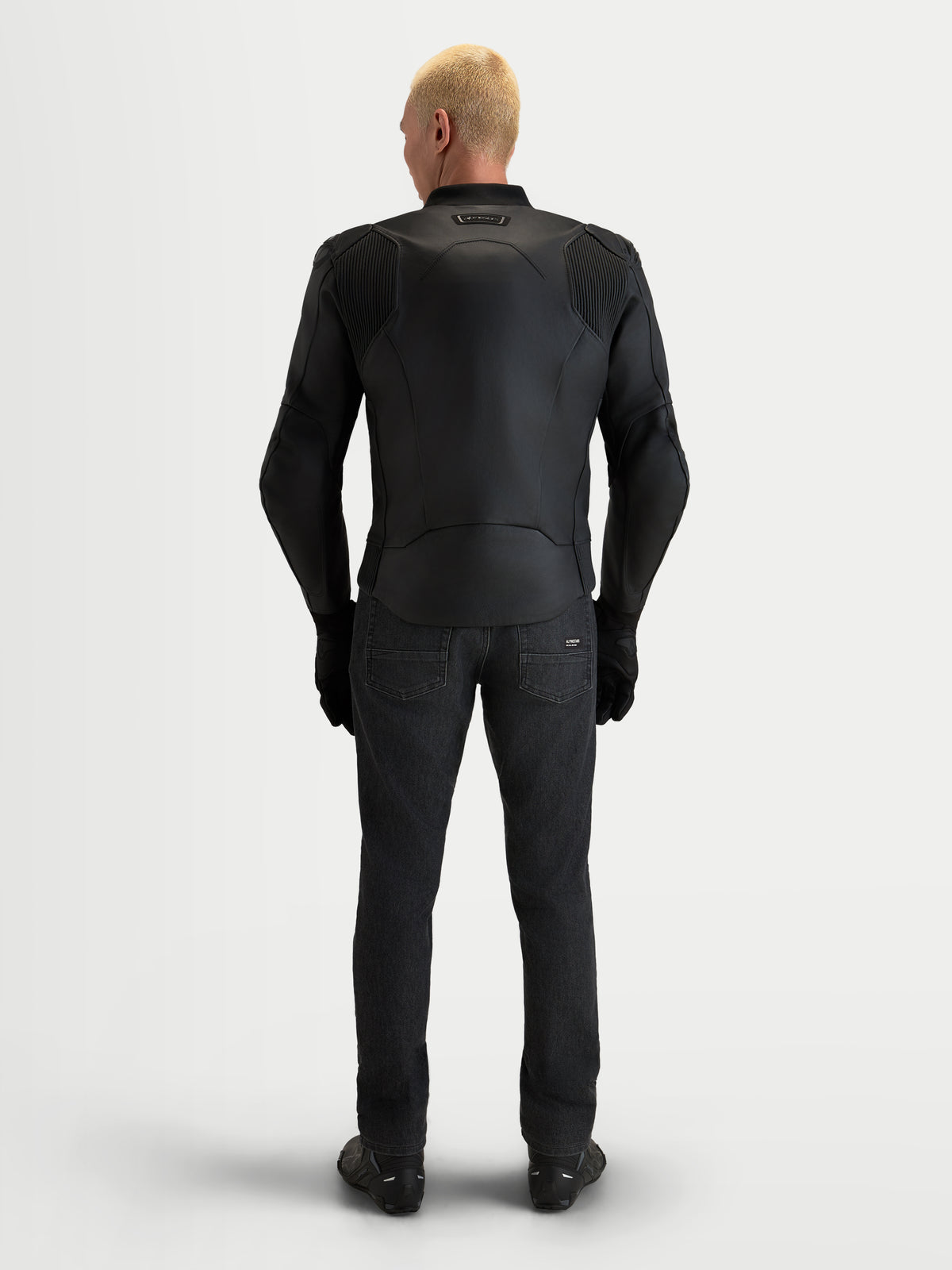 Alpinestars Caliber V2, blusão de moto em couro para homem, preto, vista traseira de um modelo a usar equipamento de estrada desportivo