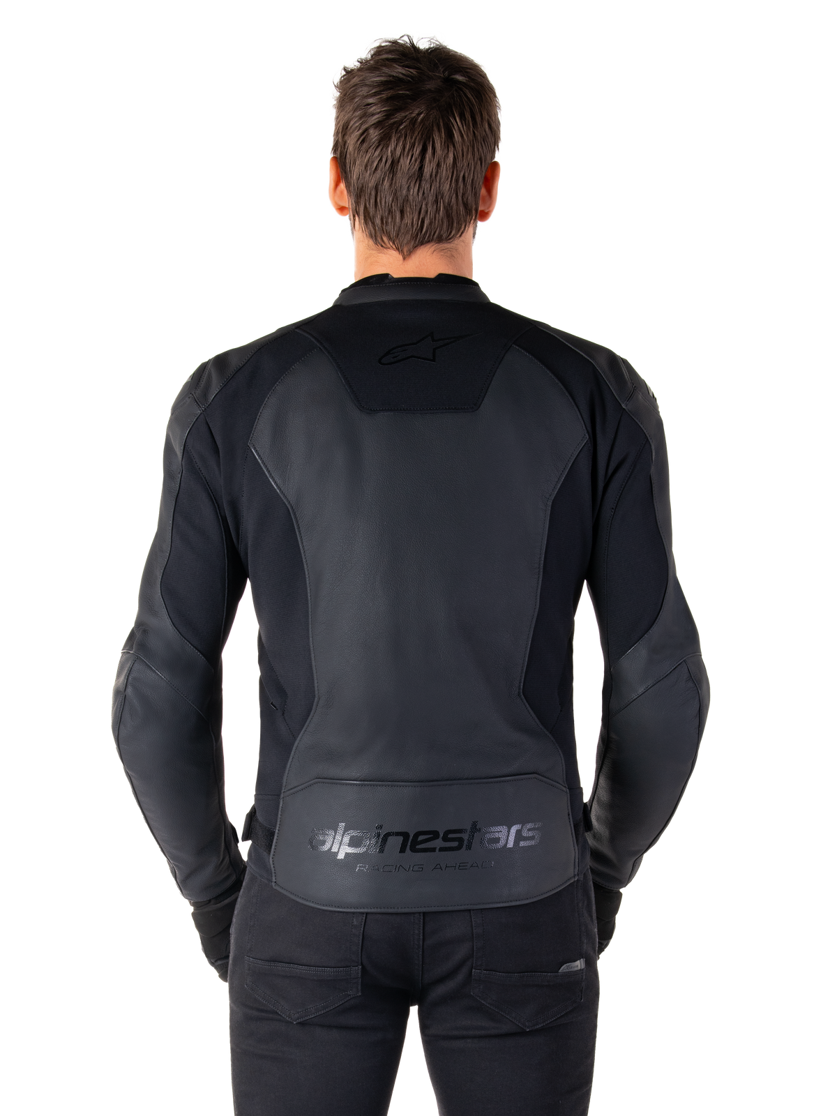 Vista traseira de um homem a usar o Casaco de Couro Alpinestars Faster V3 em Black Black, com painéis de couro premium e inserções elásticas flexíveis, branding subtil 'alpinestars' e 'RACING AHEAD' na parte inferior das costas, corte desportivo para condução de motociclos.