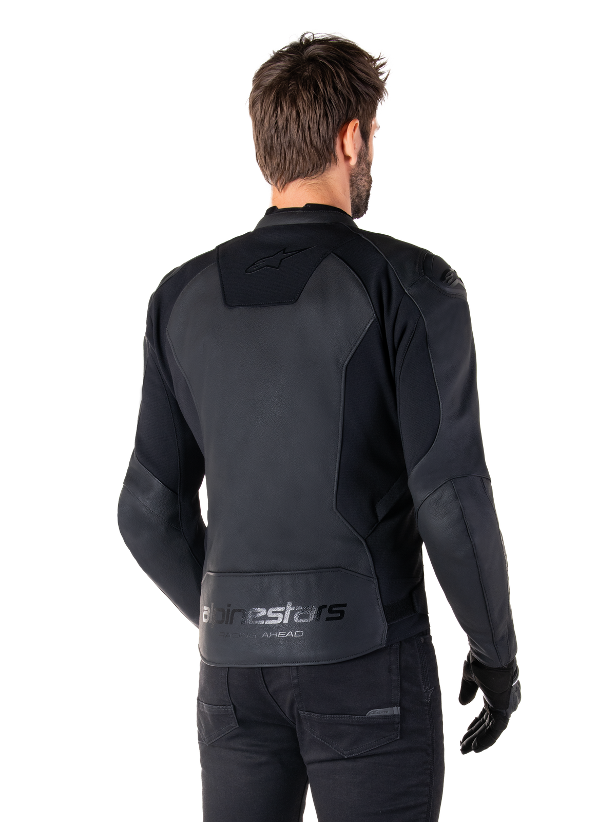 Casaco de Couro Alpinestars Faster V3, Preto, vista traseira de modelo a usar o casaco de condução desportiva, com as marcas 'alpinestars' e 'RACING AHEAD' na zona lombar, couro premium com painéis mate, silhueta desportiva moderna para motociclismo