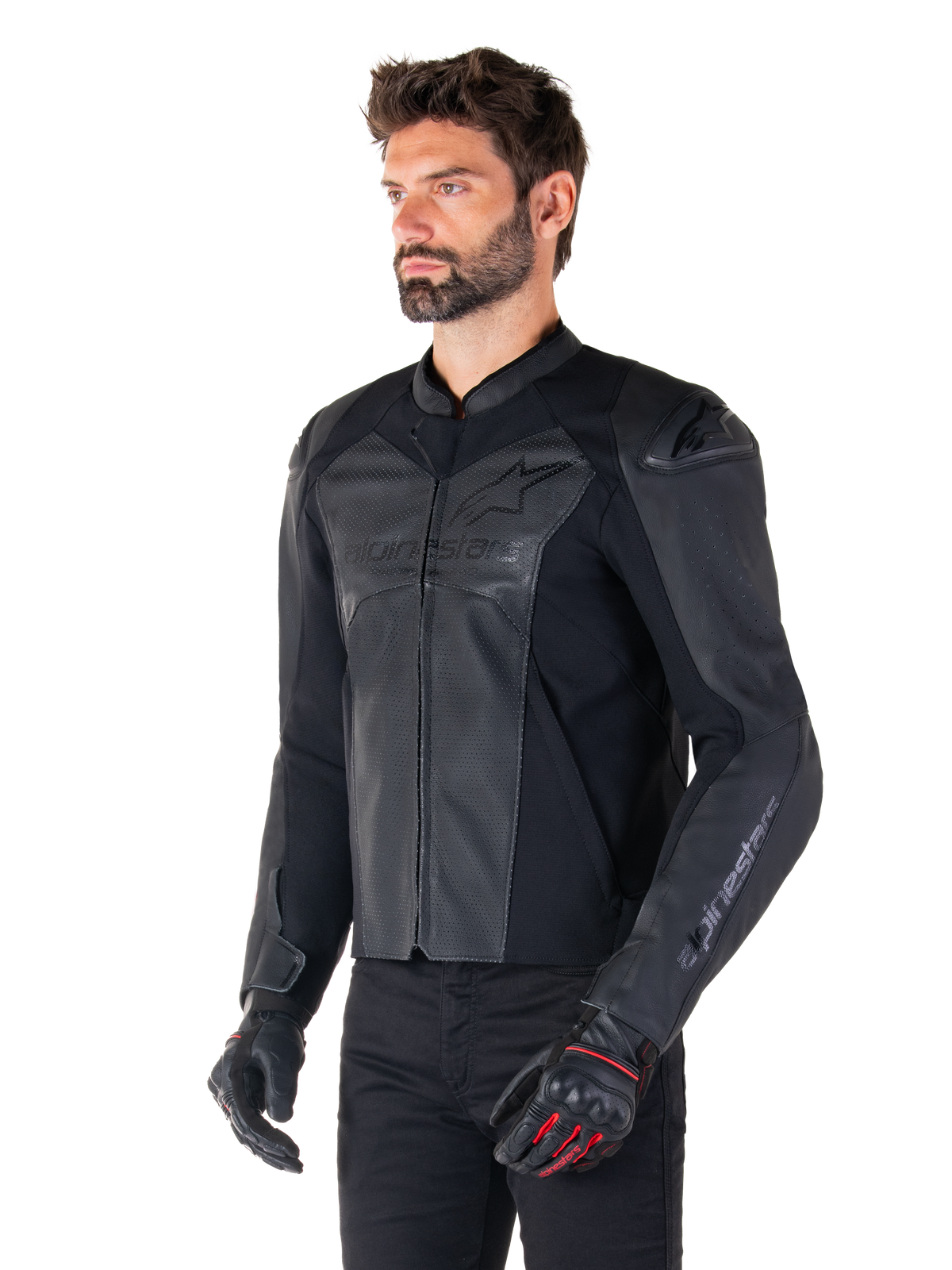 Modelo a usar o casaco Alpinestars Faster V3 Airflow Leather Jacket em Black Black, casaco de motociclismo de condução desportiva com couro perfurado e painéis elásticos, combinado com calças pretas e luvas pretas com pormenores vermelhos, estilo elegante derivado das corridas