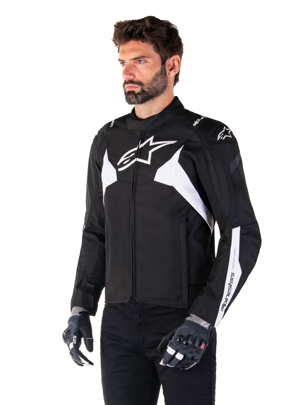 Casaco Impermeável Alpinestars T-Jaws V4, preto e branco, usado por um modelo com luvas de motociclismo, com logótipos e detalhes Alpinestars em branco proeminentes, casaco de motociclismo têxtil com corte desportivo para condução em estrada