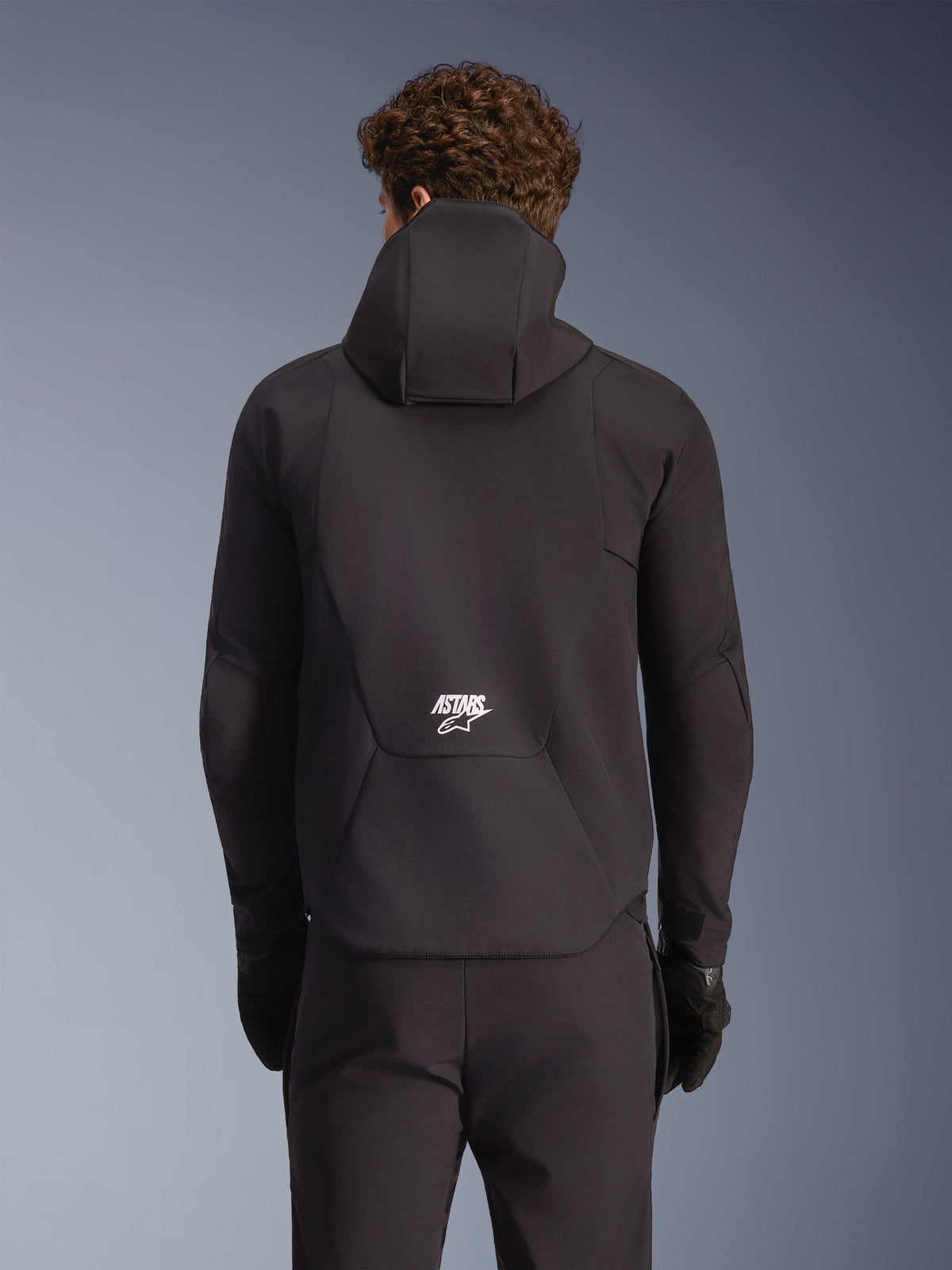 Alpinestars Aeroshell Waterproof Jacket, casaco de moto para homem, preto, vista traseira com capuz e logótipo branco.