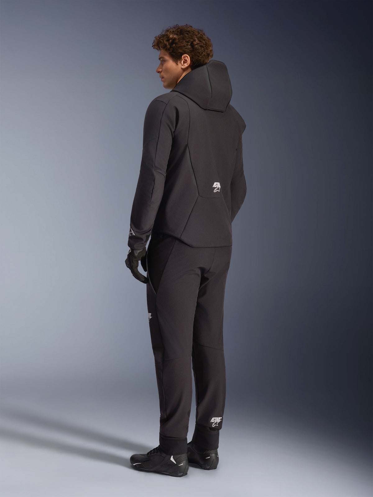 Alpinestars Aeroshell, casaco com capuz de moto impermeável, homem, em softshell preto, vista traseira no modelo.