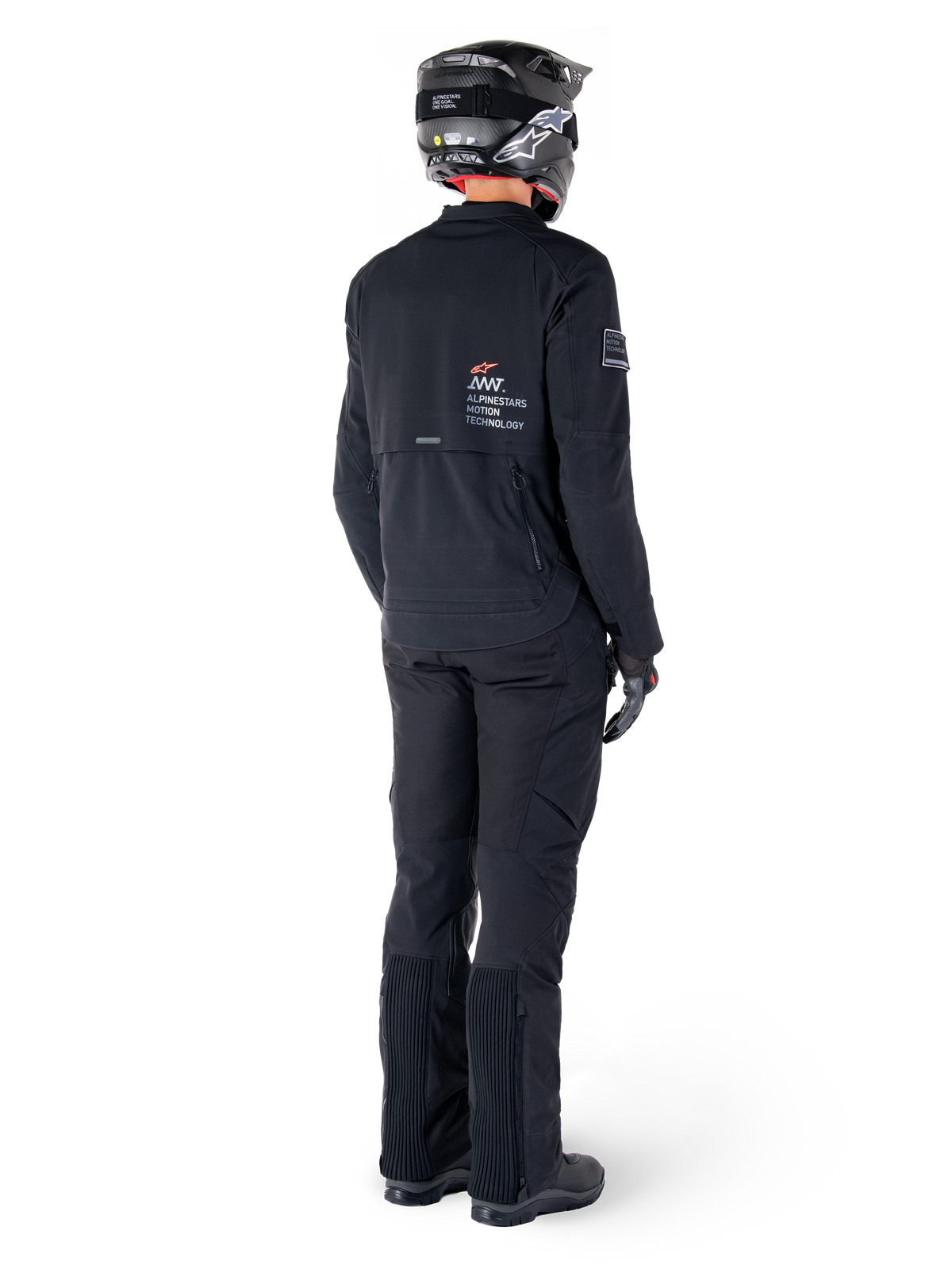Casaco Alpinestars AMT-8 Stretch Drystar® XF, preto, vista traseira de um motociclista a usar o casaco com calças pretas a condizer e um capacete preto, com a marca 'Alpinestars Motion Technology' nas costas, material elástico técnico para motociclismo de aventura
