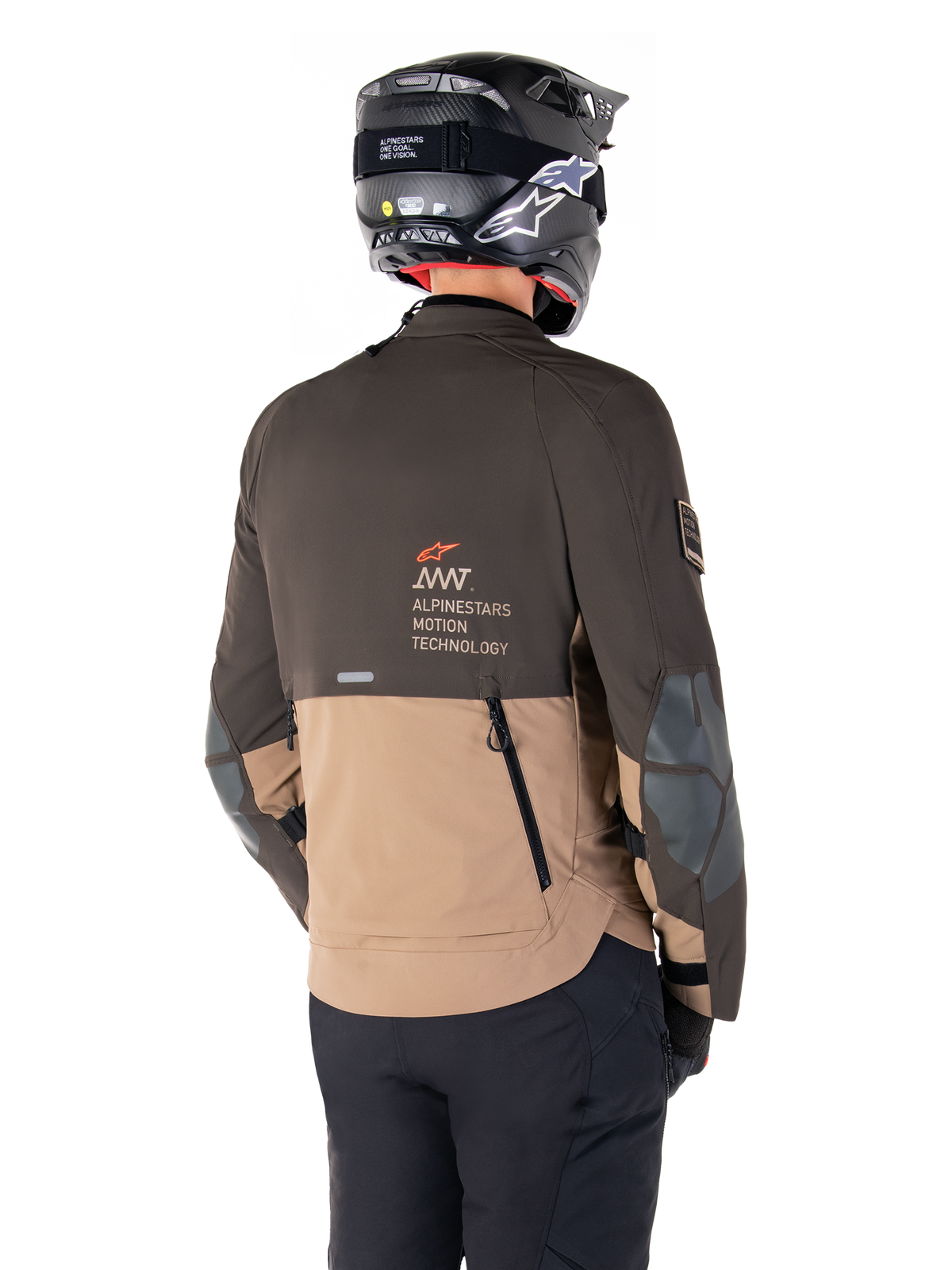Alpinestars AMT-8 Stretch Drystar® XF Jacket, casaco de motociclismo de aventura, castanho escuro e caqui escuro, vista traseira mostrando a marca AMT Alpinestars Motion Technology, design têxtil bicolor com fechos de ventilação traseiros e exaustão estilo telha, usado com capacete preto e calças de motociclismo