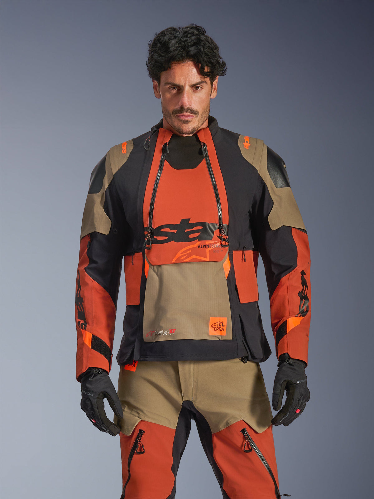Alpinestars Jaqueta Halo Pro Drystar XF Laminada, casaco de moto adventure para homem, castanho-ferrugem, preto e castanho-claro, vista frontal num modelo com construção impermeável laminada e ventilação modular