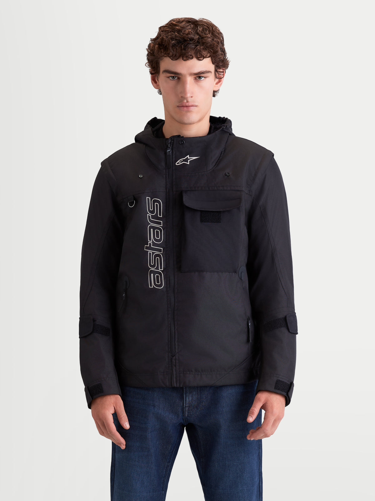 Alpinestars Morfex Parka Waterproof Jacket, casaco de moto urbano contemporâneo para homem em preto, vista frontal num modelo a mostrar estilo parka modular, capuz integrado e pormenores de bolso no peito