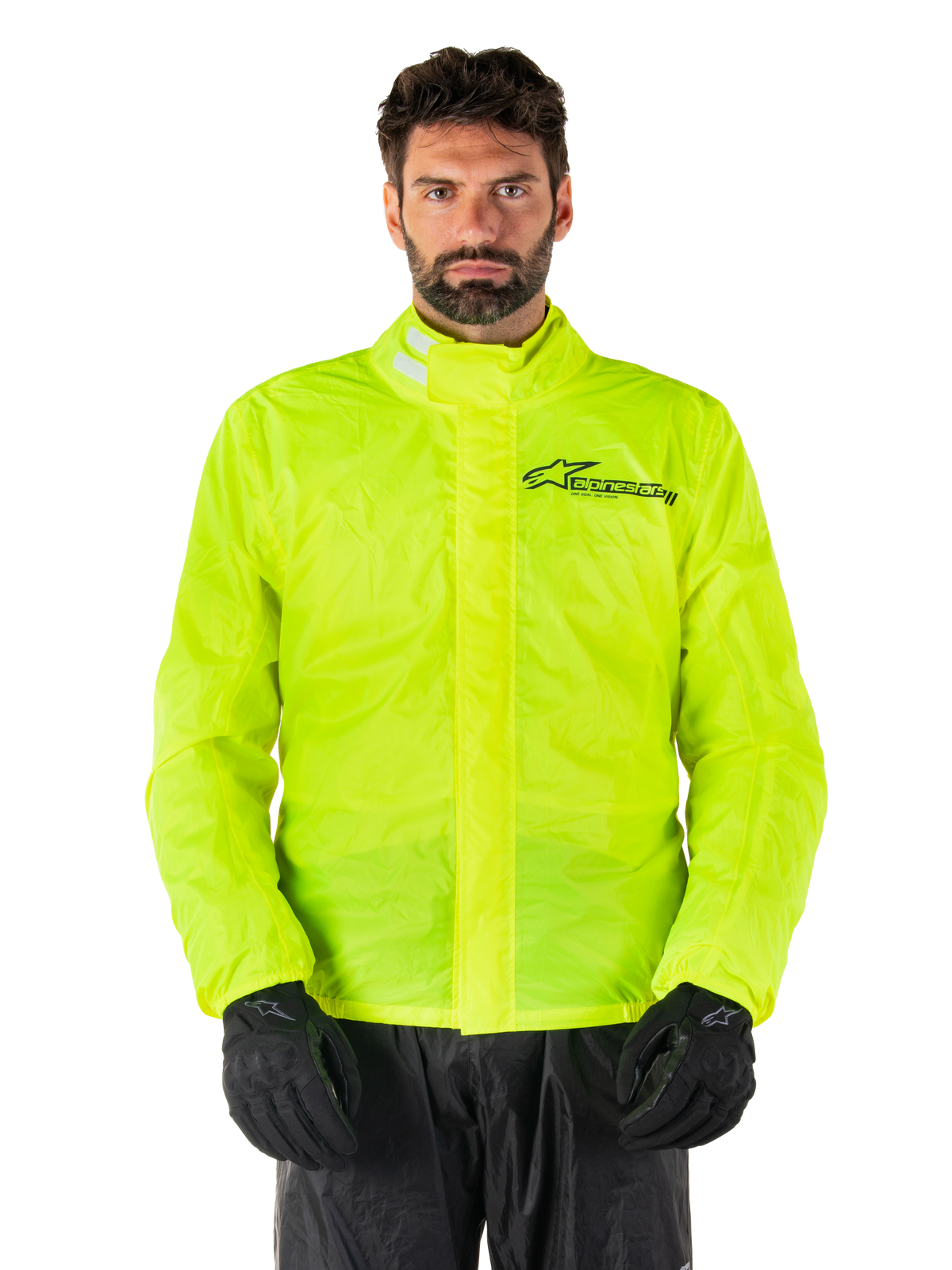 Casaco Alpinestars Hurricane Rain V2, casaco de chuva para moto, amarelo fluorescente, usado por um modelo com calças e luvas pretas, gola alta com abas refletoras, aba protetora frontal com logótipo Alpinestars, equipamento impermeável de alta visibilidade