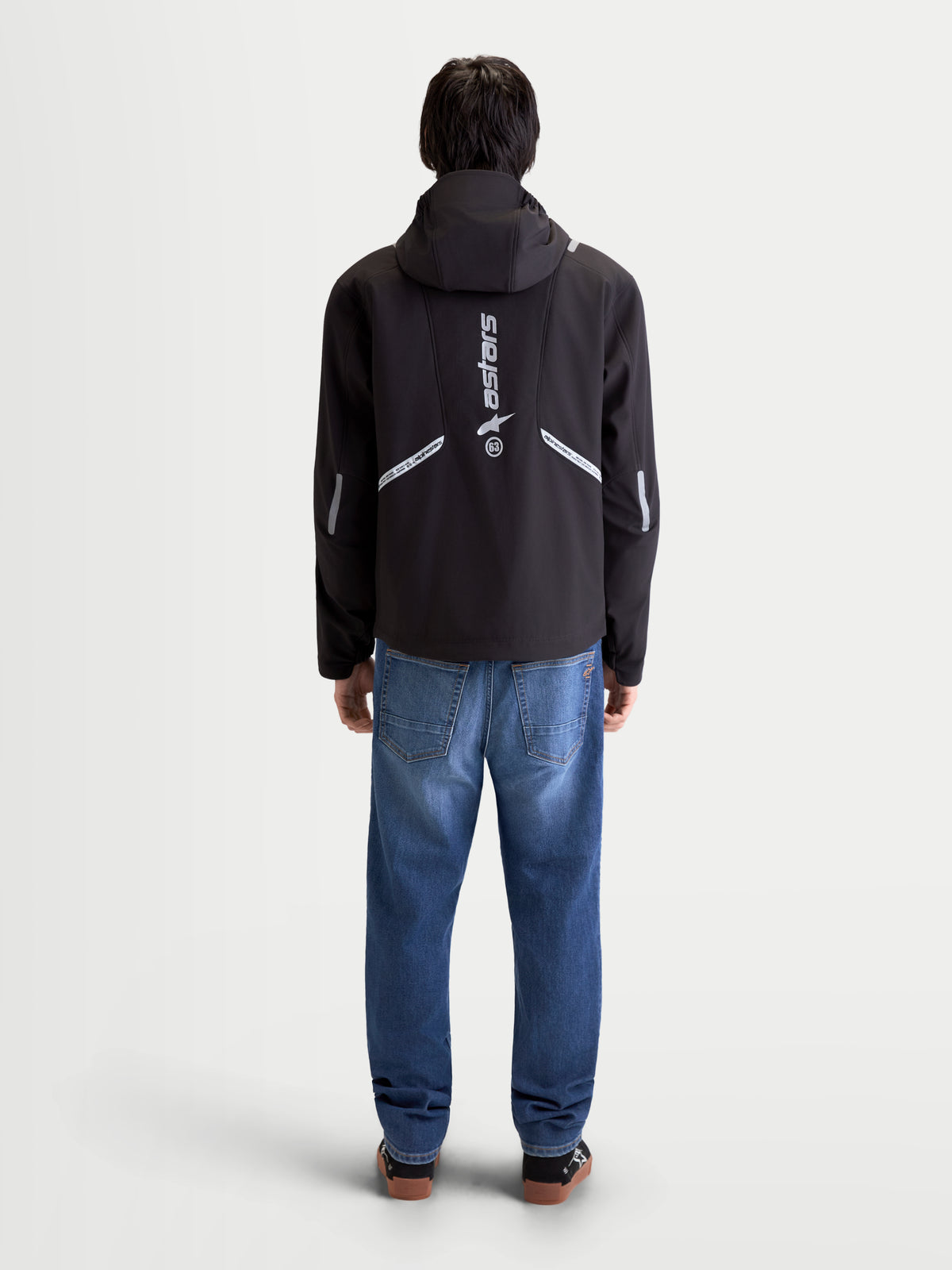 Alpinestars C-5 Drystar, blusão de moto urbano para homem, preto, vista traseira num modelo a usar o casaco com capuz integrado e pormenores refletores