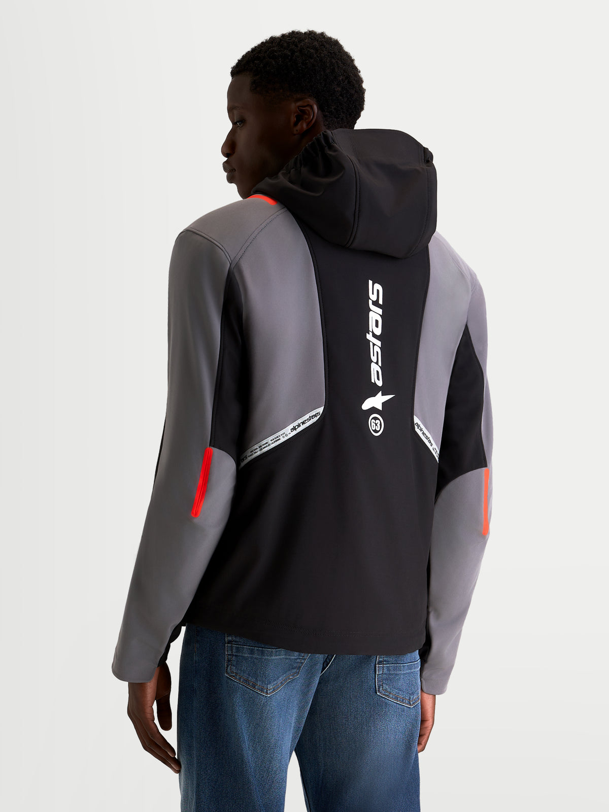 Alpinestars C 5 Drystar casaco, blusão de moto urbano softshell para homem em preto e cinzento escuro, vista traseira num modelo a mostrar o capuz integrado, logótipo grande da Alpinestars nas costas e construção em tecido impermeável