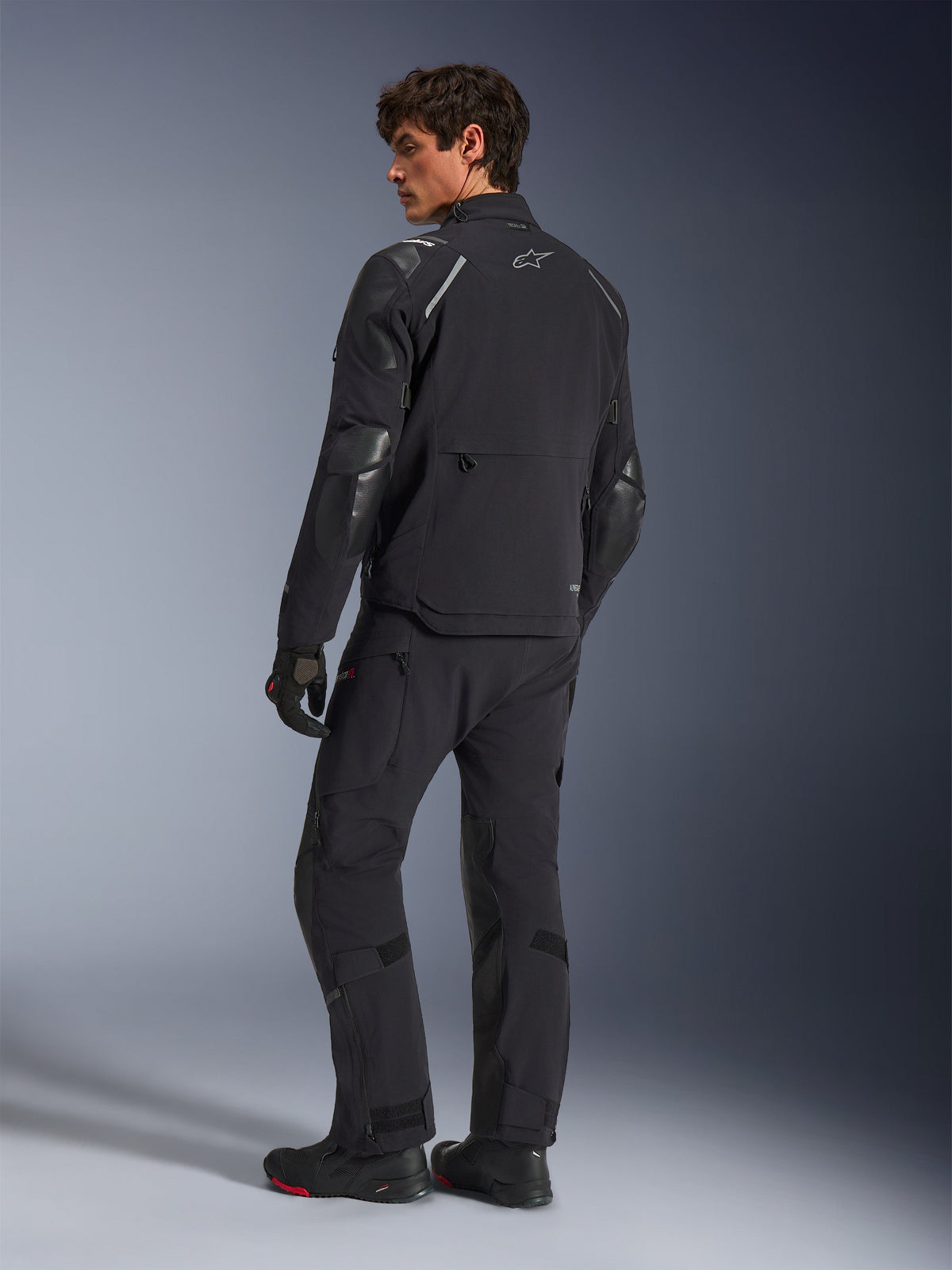 Casaco Alpinestars Andes Pro Drystar® XF, casaco de motociclismo de aventura, preto, vista traseira, usado com calças e botas a condizer, com painéis reforçados e logótipo de estrela prateada, equipamento técnico de condução para todas as condições climatéricas