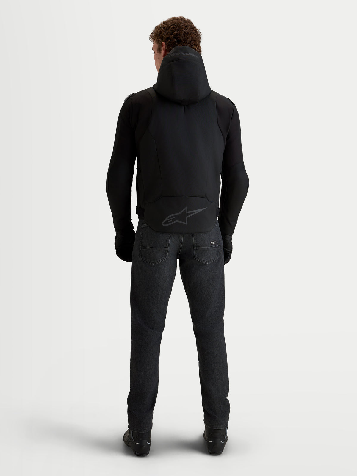 Alpinestars Zaca V2 Waterproof Casaco, blusão de moto para homem, preto, vista traseira num modelo com capuz integrado e logótipo tonal na bainha traseira
