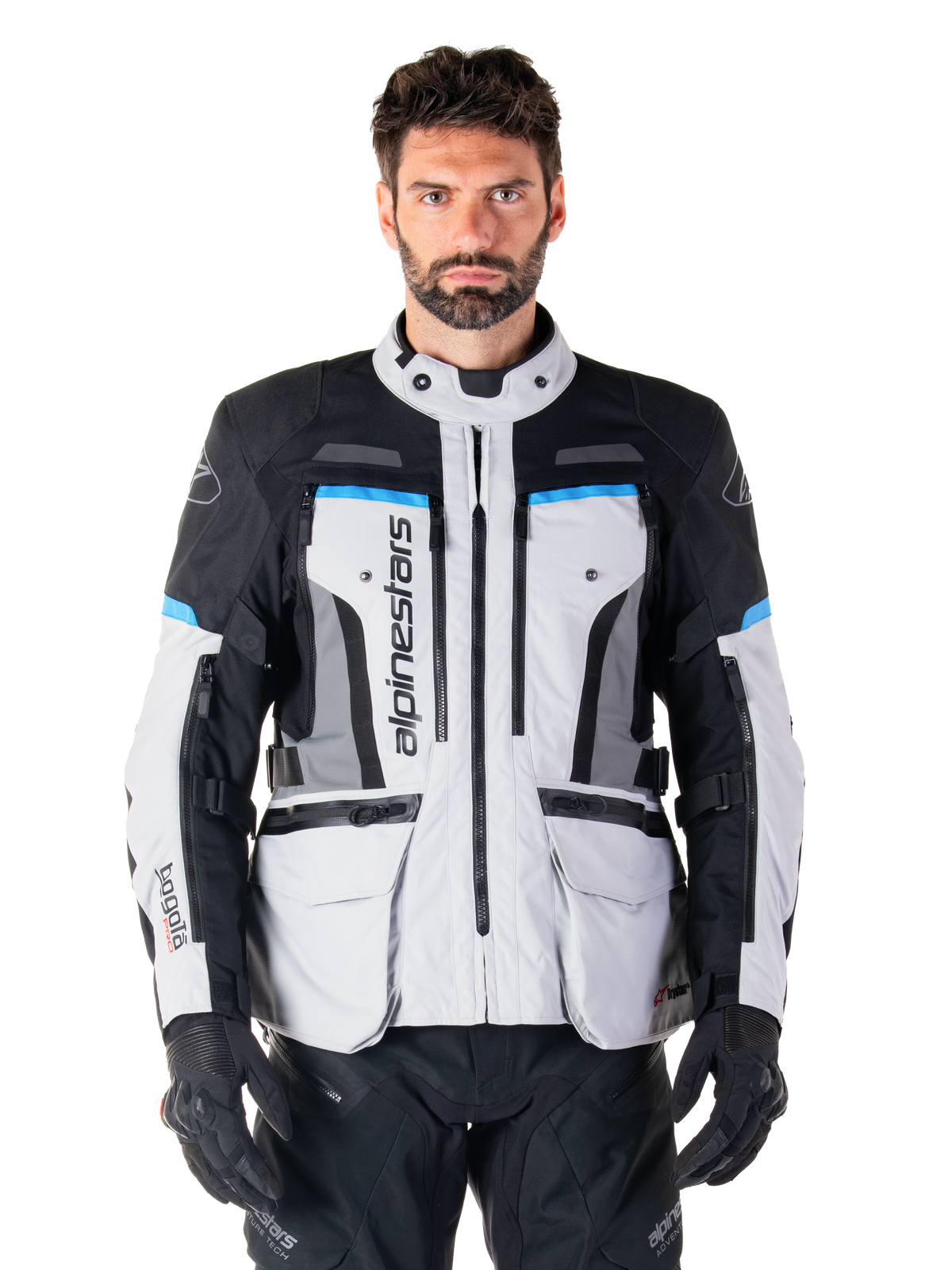 Alpinestars Bogota Pro Drystar, casaco de moto para turismo de aventura para homem, cinzento gelo, preto e ciano, impermeável, modelo a usar calças e luvas pretas