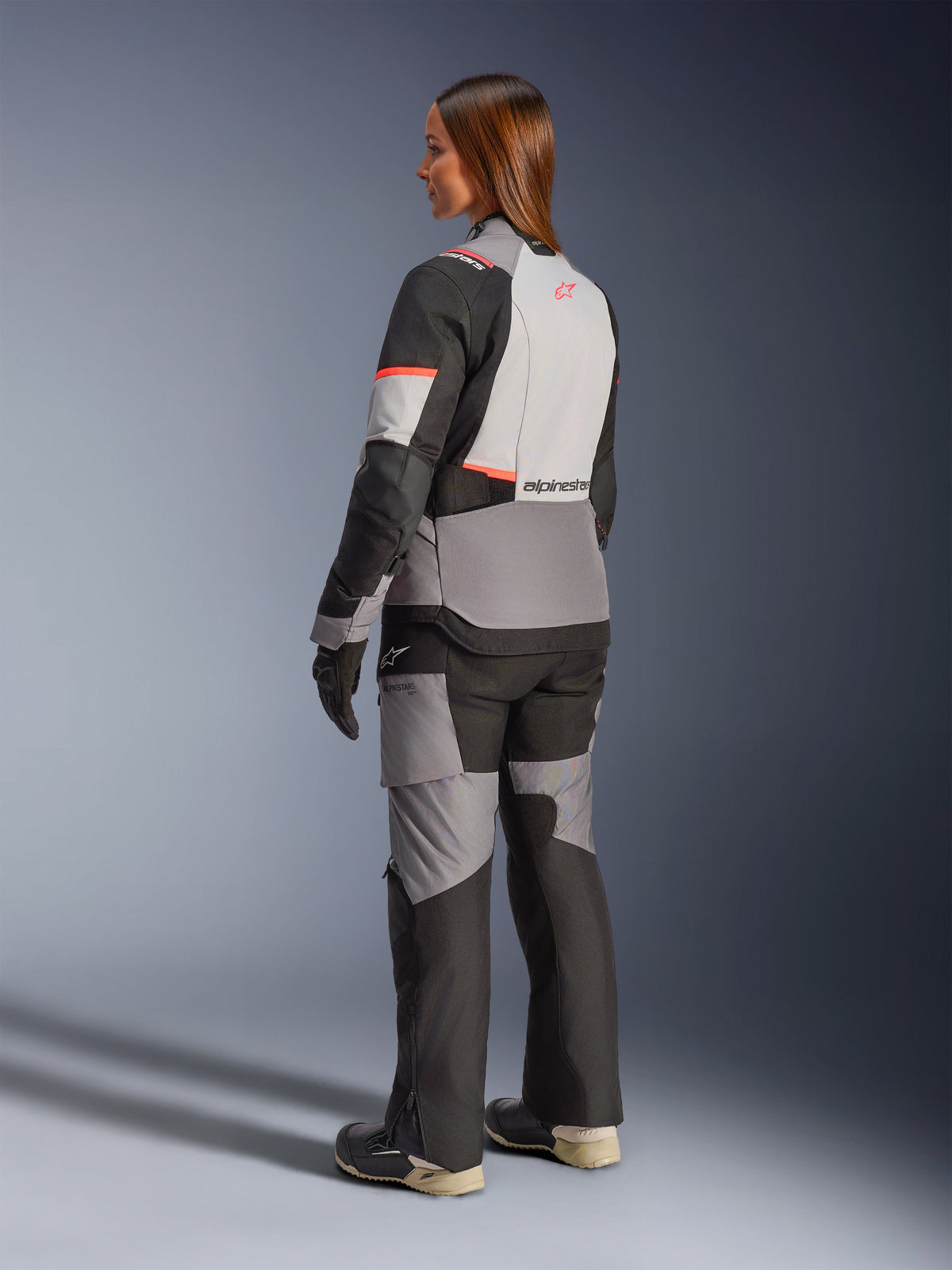 Alpinestars Stella Andes V4 Drystar, casaco de moto para aventura e touring para mulher, cinzento e preto com detalhes coral, impermeável, vista traseira.