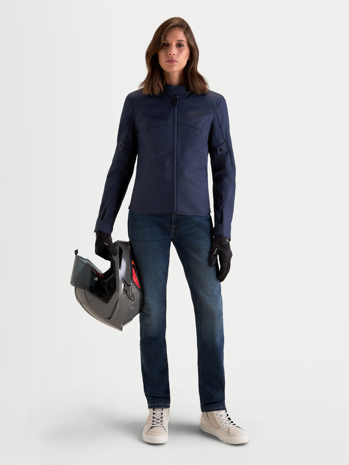 Alpinestars Stella C-1 Waterproof casaco de moto urbano para mulher, azul indigo, vista frontal num modelo a segurar um capacete, com construção durável em tecido polifibra
