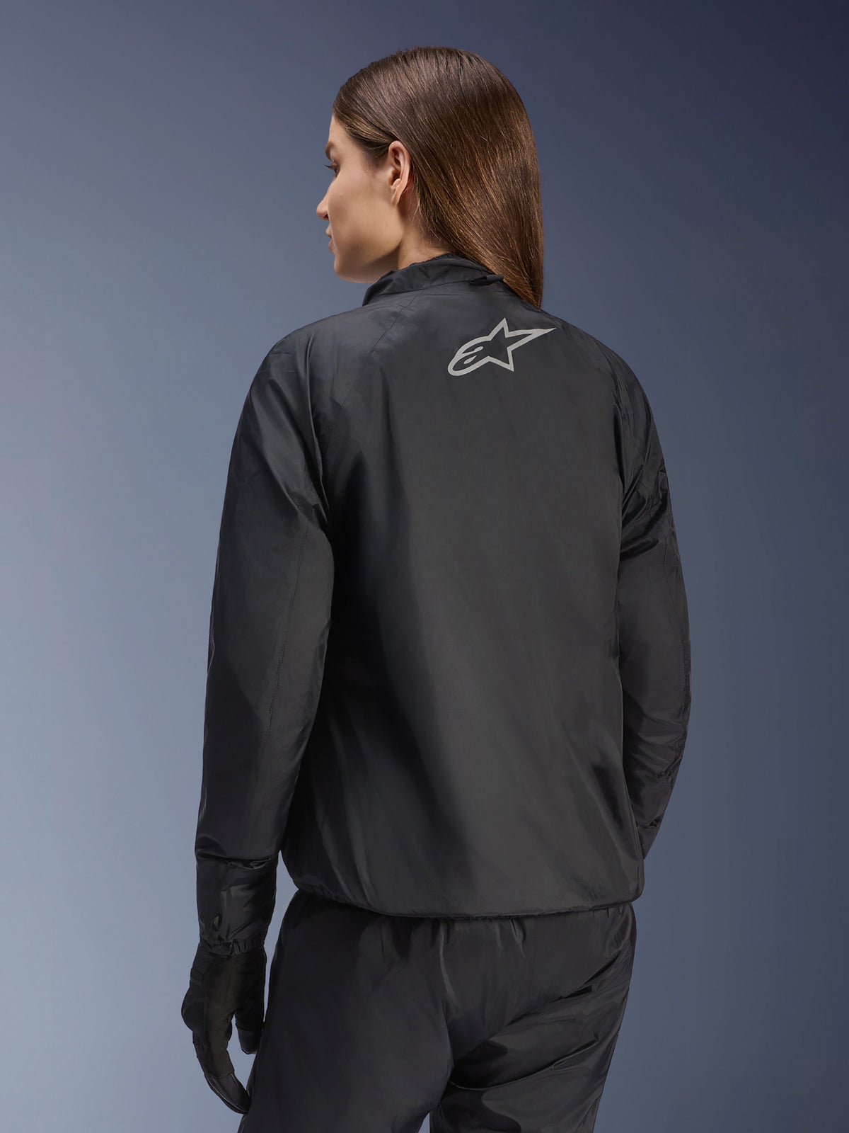 Casaco Alpinestars Stella Andes Air Drystar®, casaco de motociclismo para mulher, preto, vista traseira mostrando o logótipo da estrela prateada, combinado com calças e luvas pretas, equipamento de touring leve e impermeável