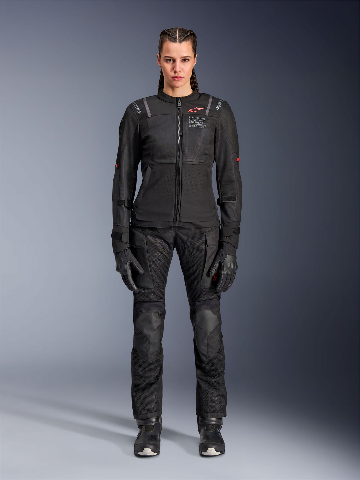Alpinestars Stella ST-2 Air Jacket, Black, full-body studio view of a female rider wearing matching black motorcycle pants and gloves, featuring high-flow mesh panels, red logo details, and a modern touring design